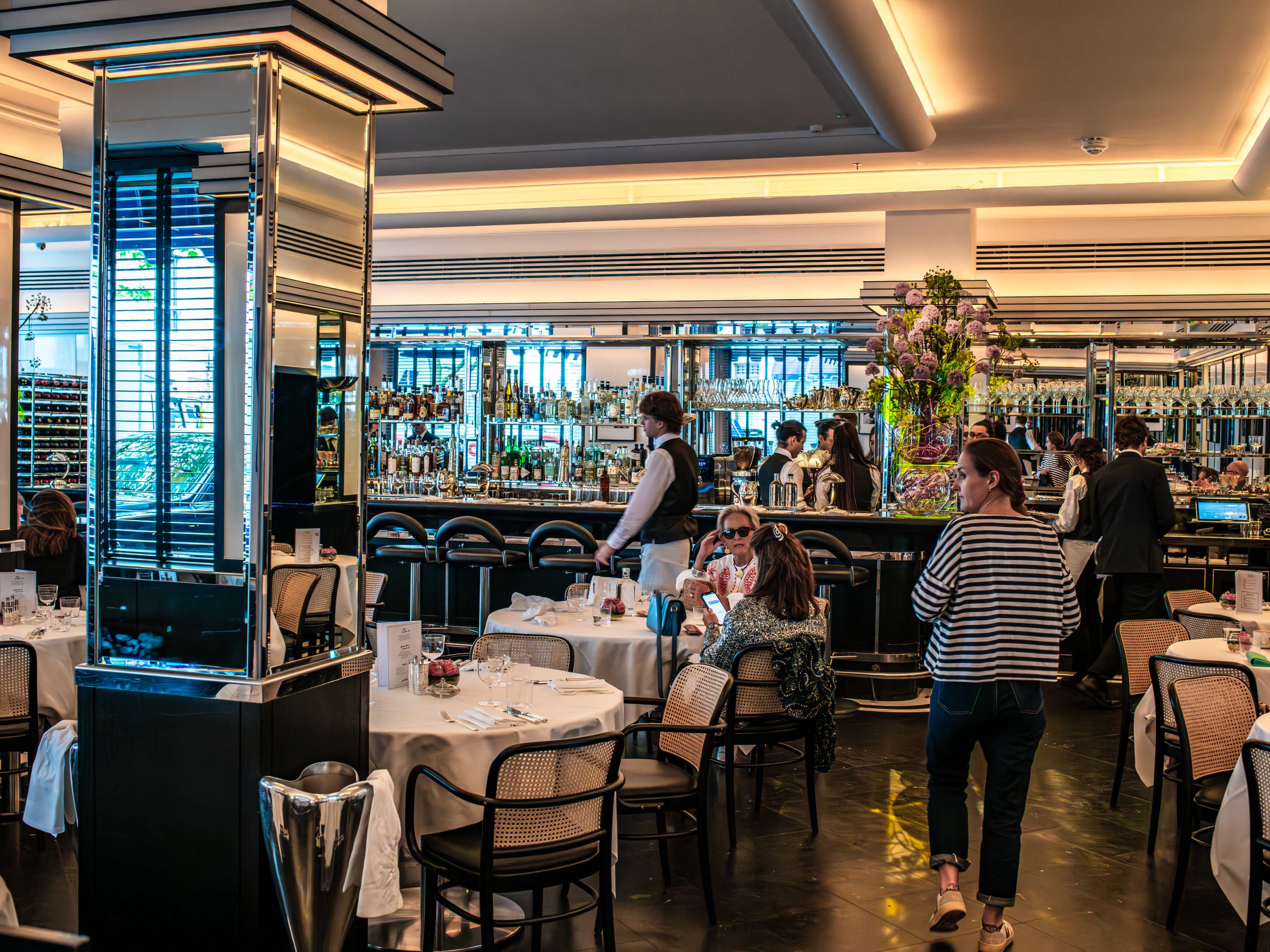 The dining room and bar at Arlington. There are mirrors covering most of the walls and columns.