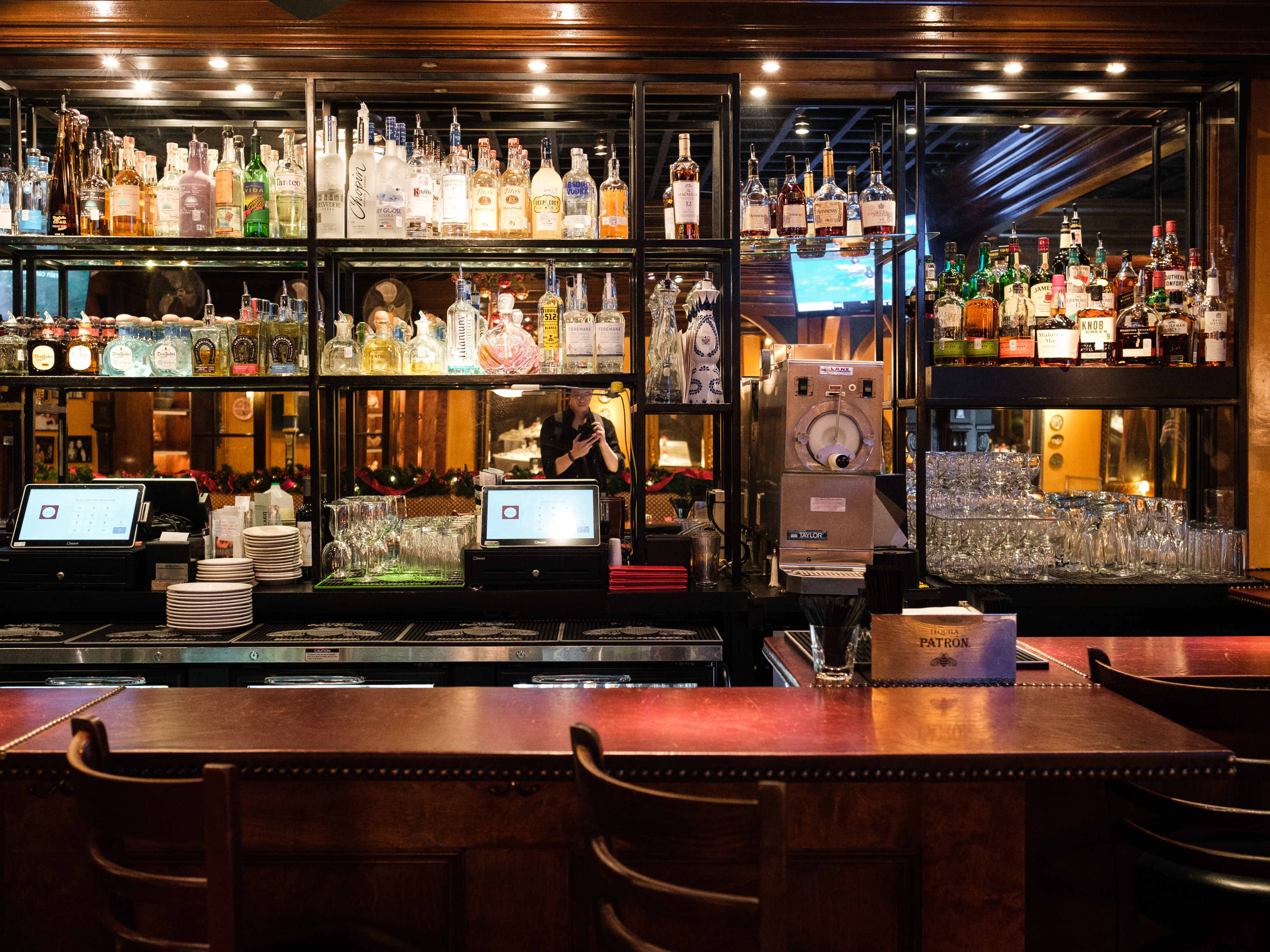 bar area of Armando's with a mirror on the back, bottles of alcohol, and a read bar top