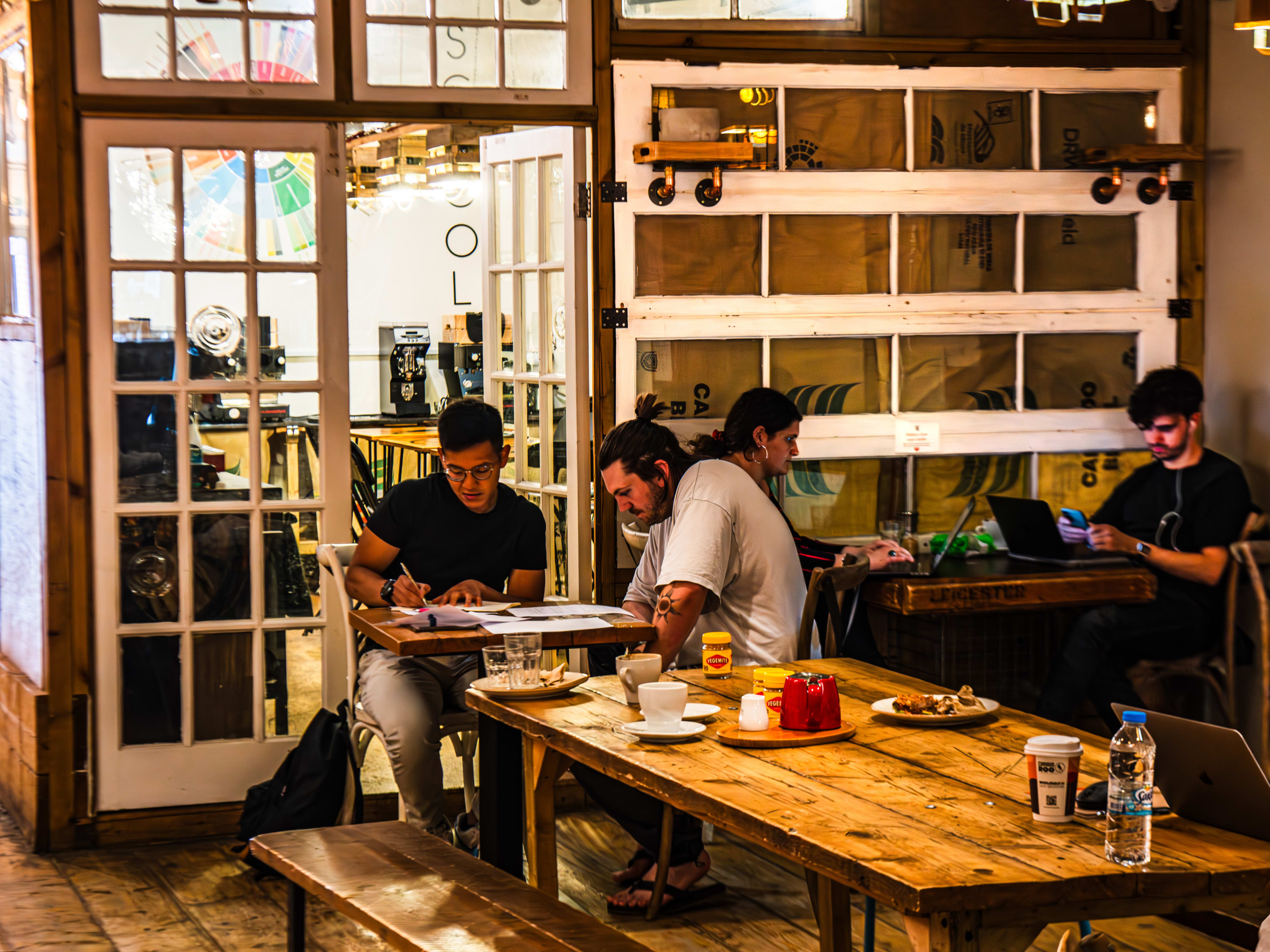 People working at tables at Artisan Coffee School.