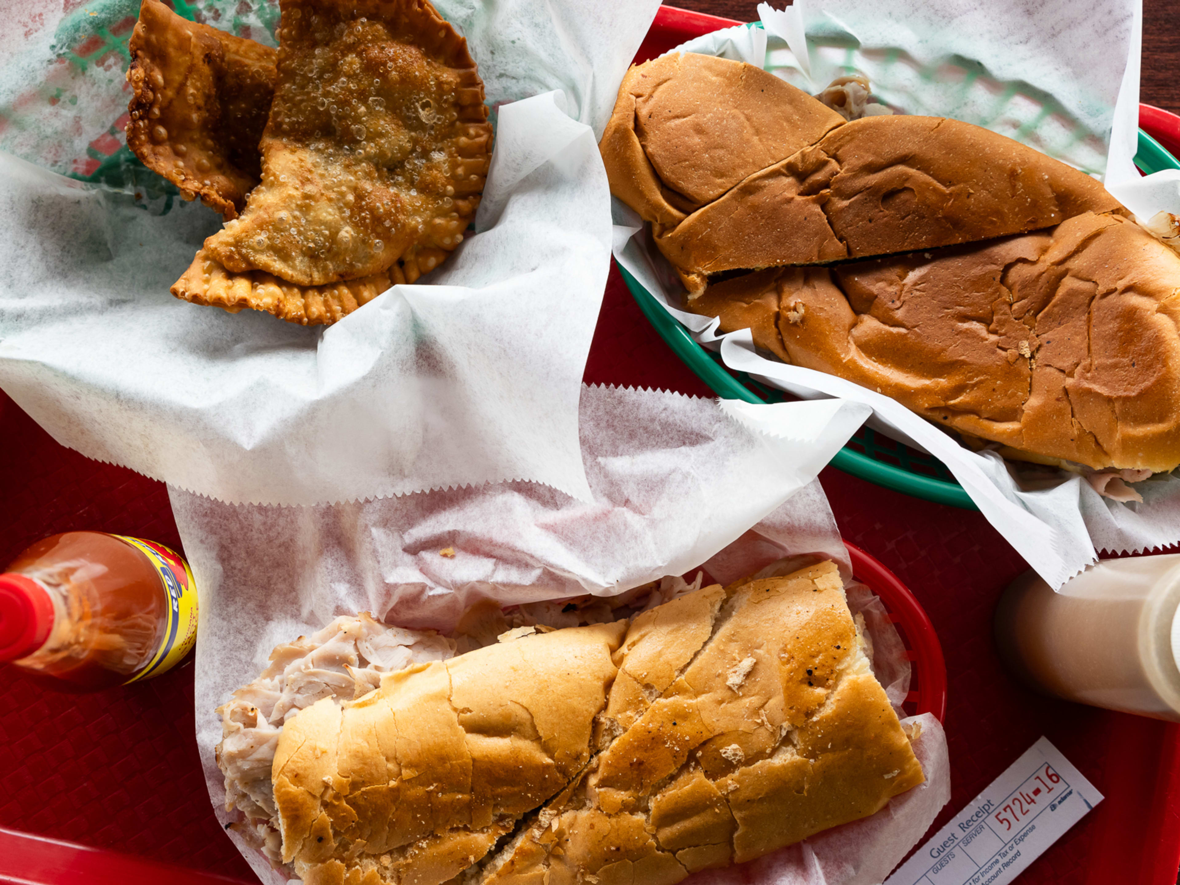 A food spread of empanadas and cubans.