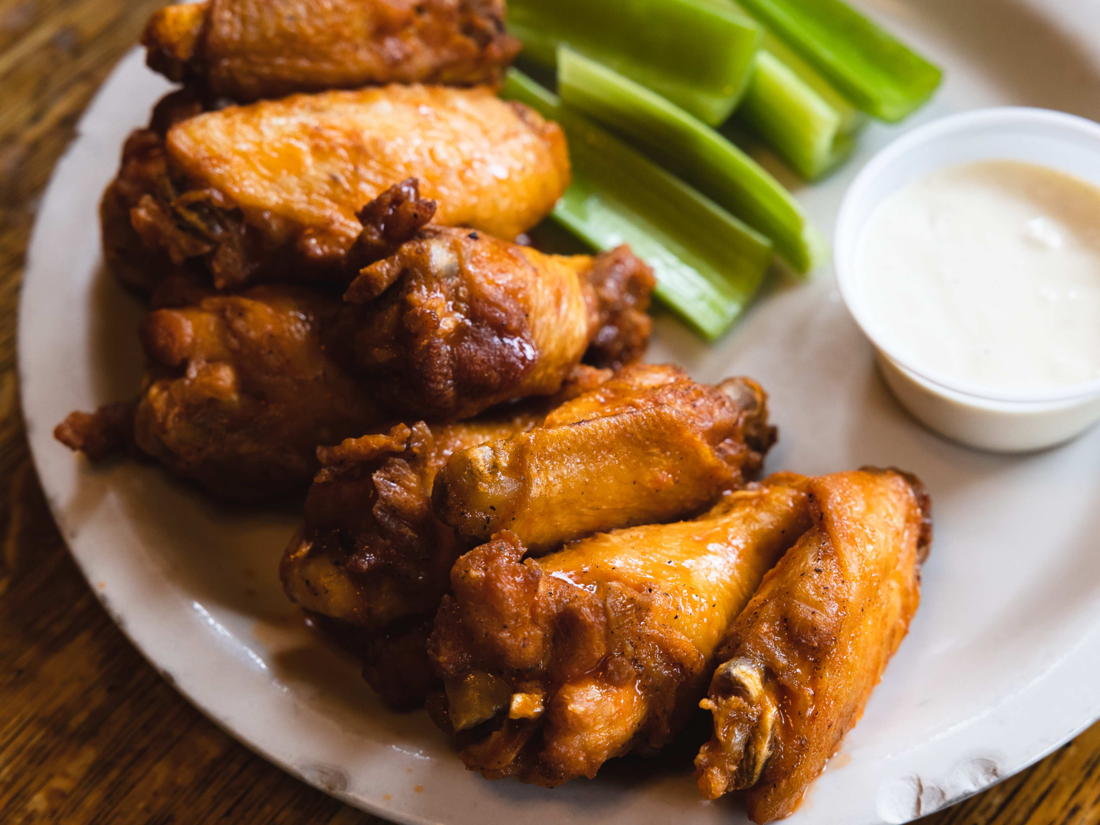 A pile of hot wings with a side of ranch.
