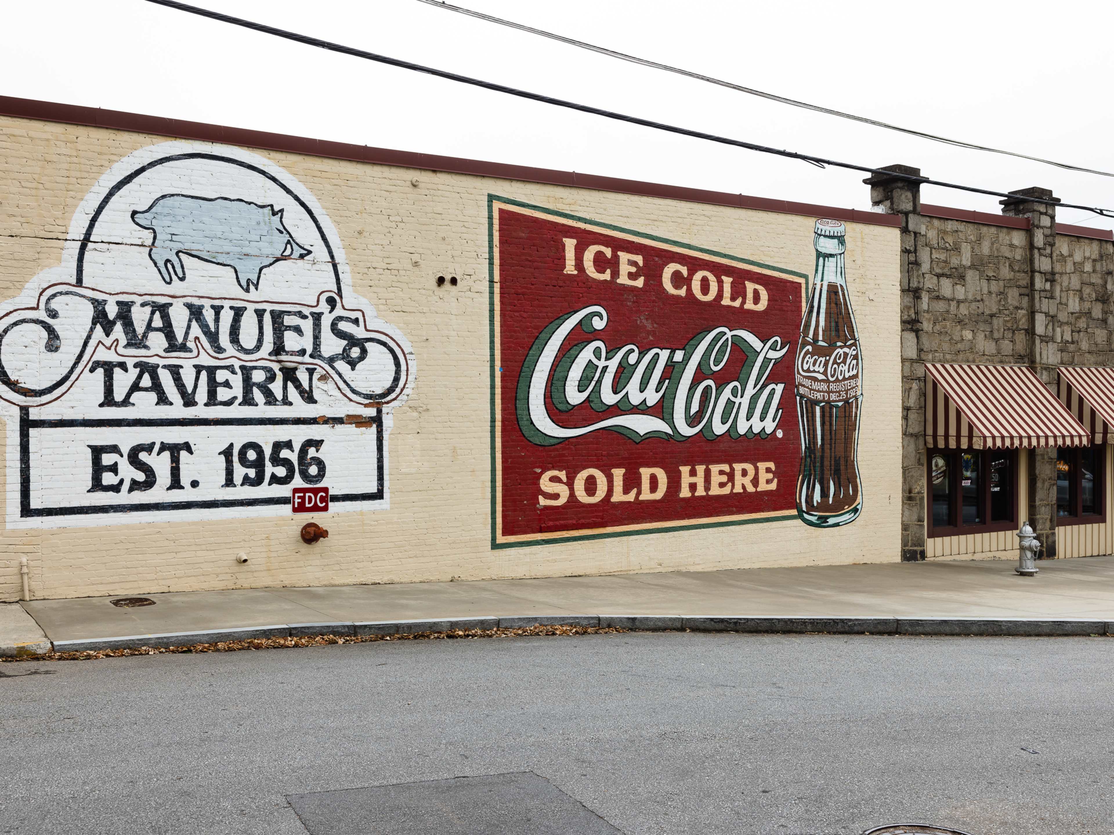 A mural that says Manuel's Tavern Est. 1956.