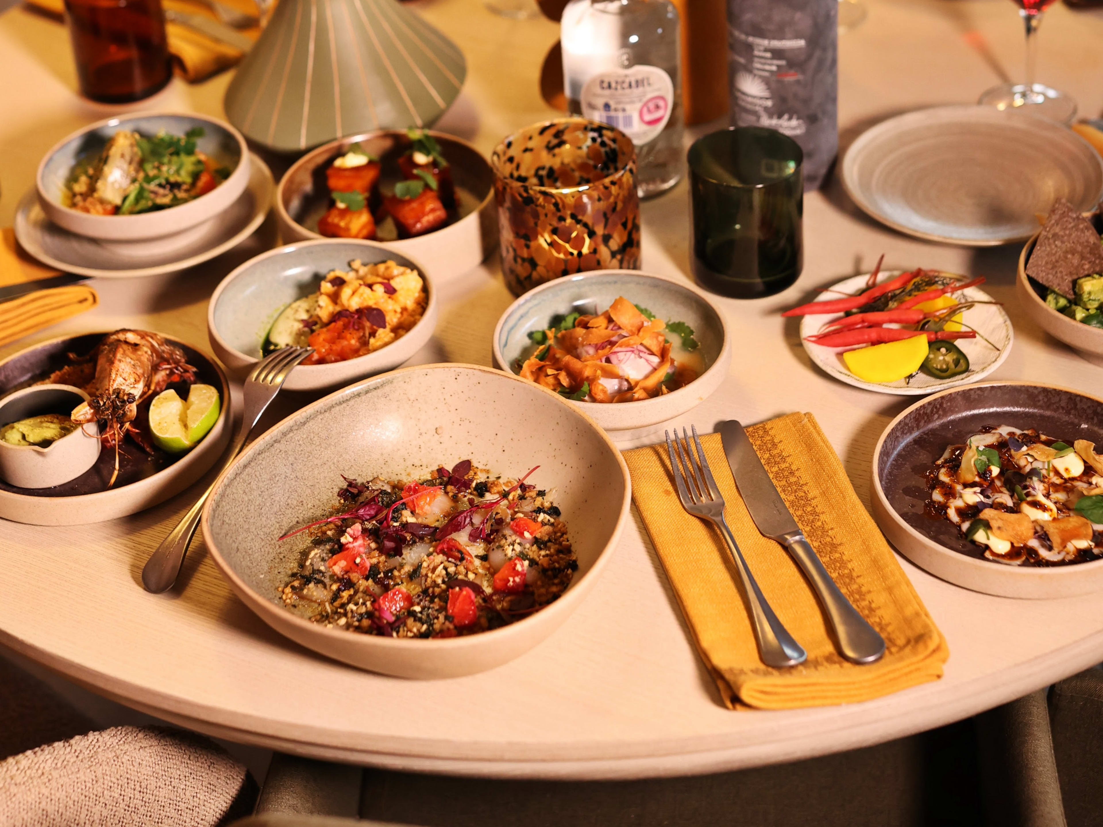 A selection of Mexican dishes on a light wood table.