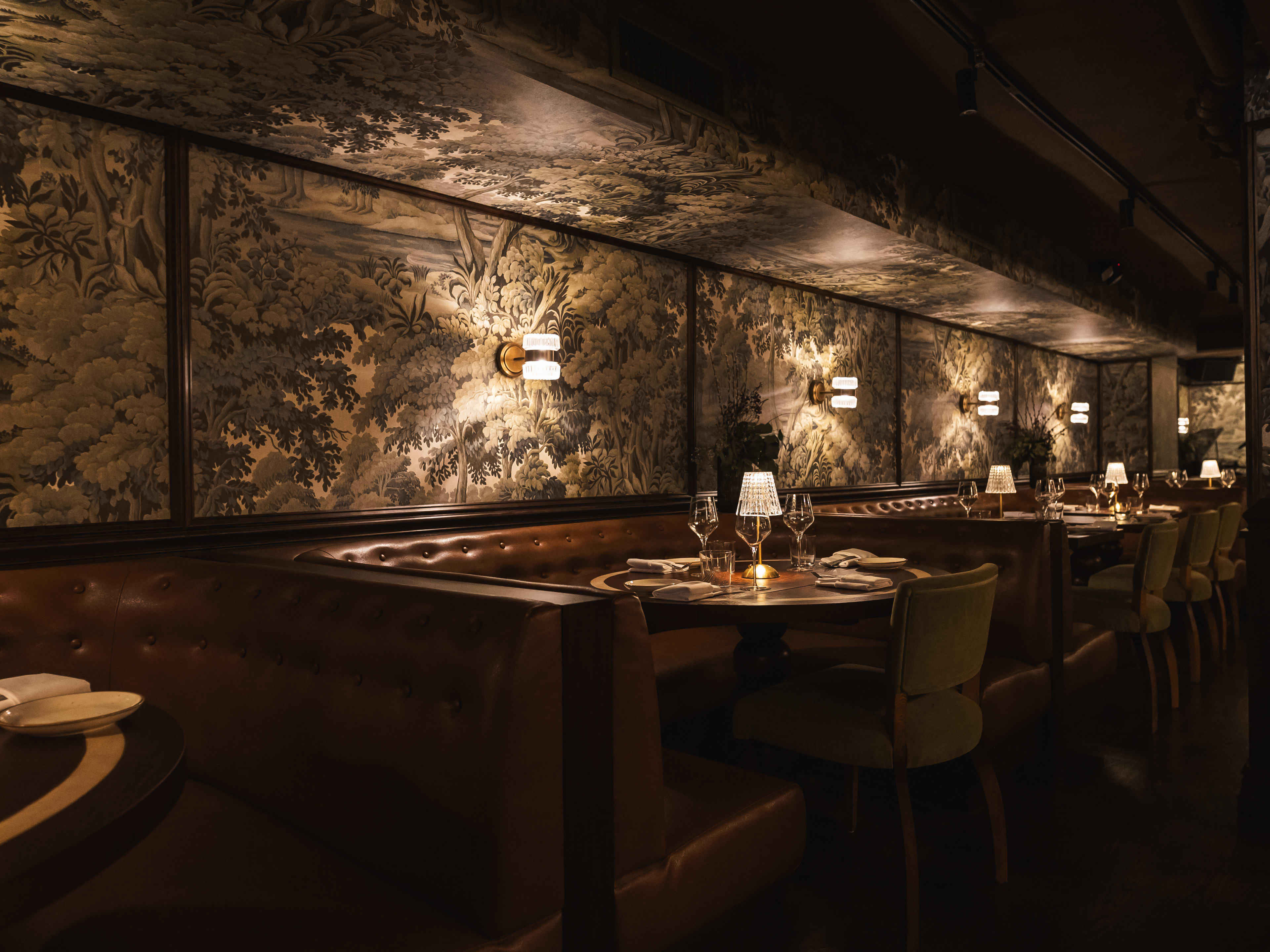 the dining room, with a few leather booths and floral wallpaper, at Chelsea Living Room