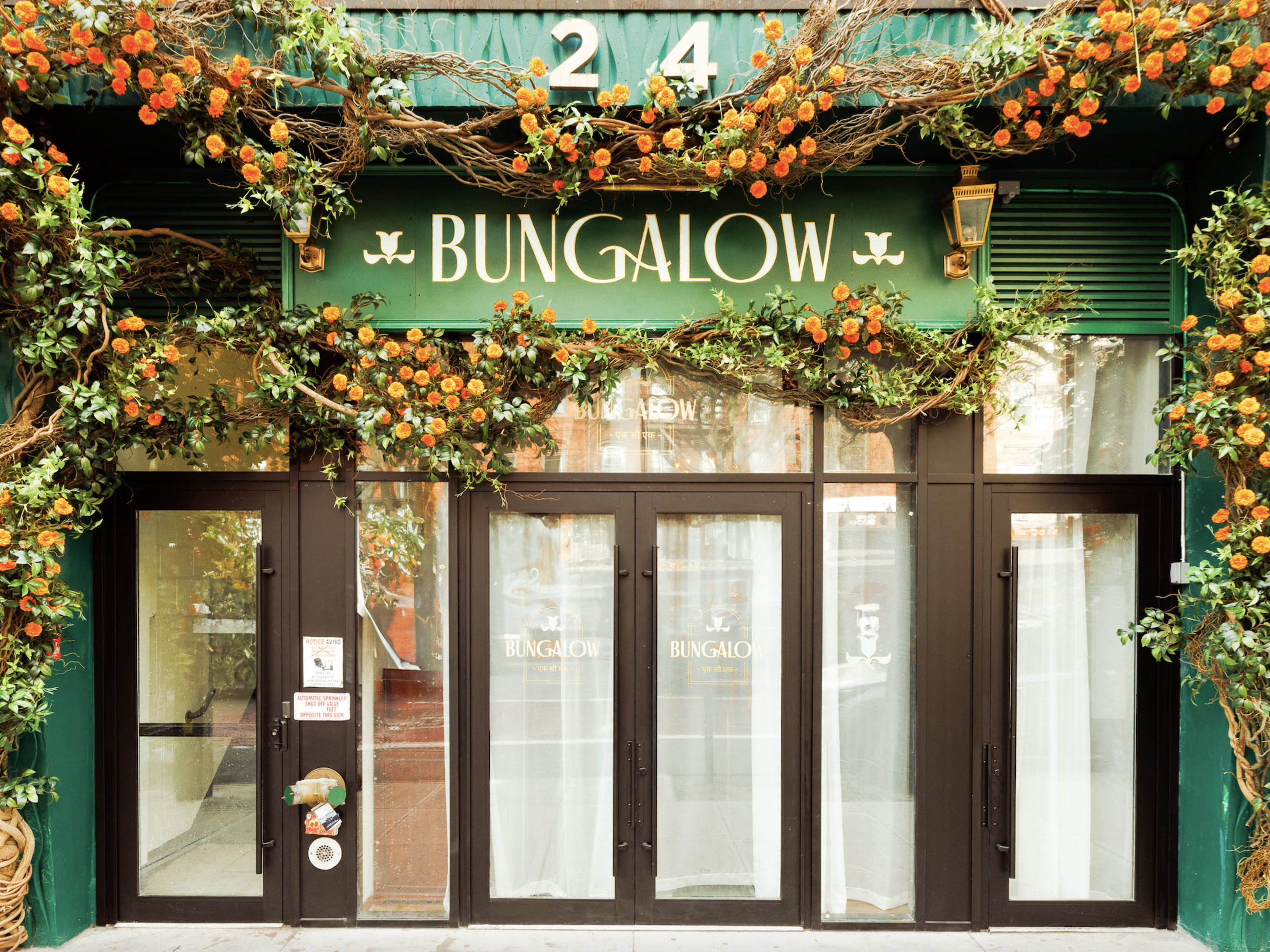 A restaurant exterior covered with fake vines and flowers.