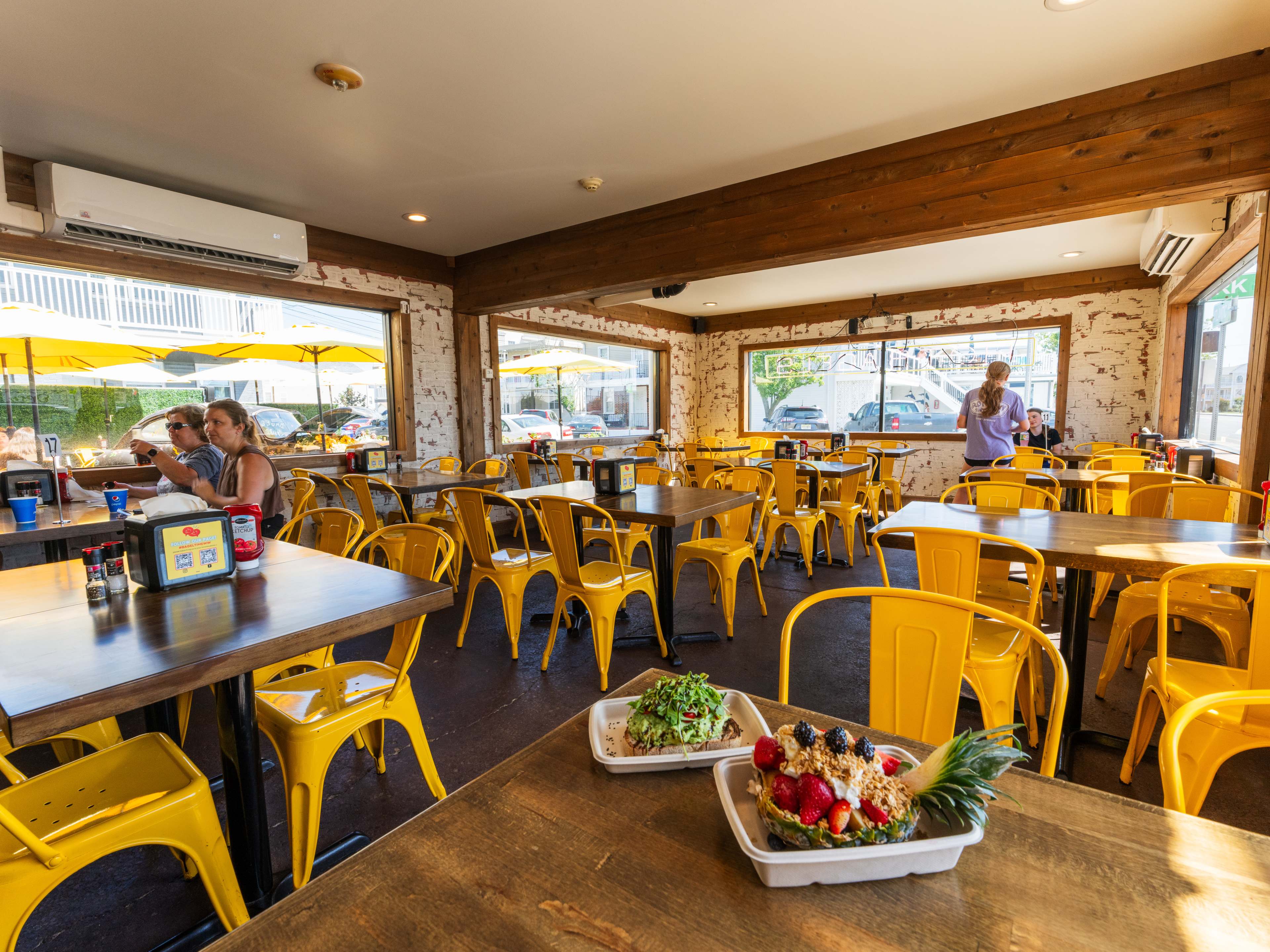 interior of casual bagel shop with colorful chairs and an avocado toast on the table