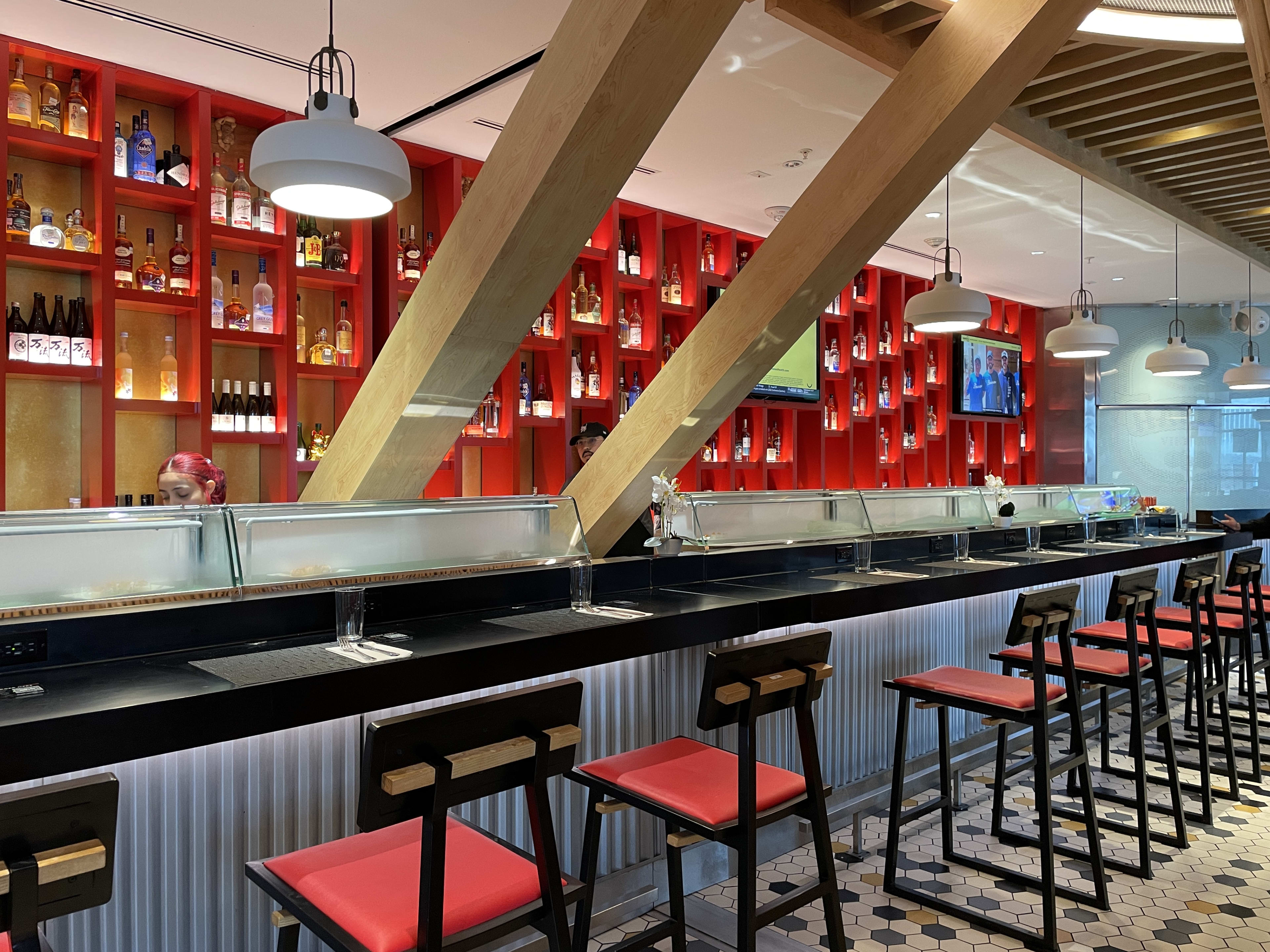 interior bar of bam bam, with red and black seats and a black counter