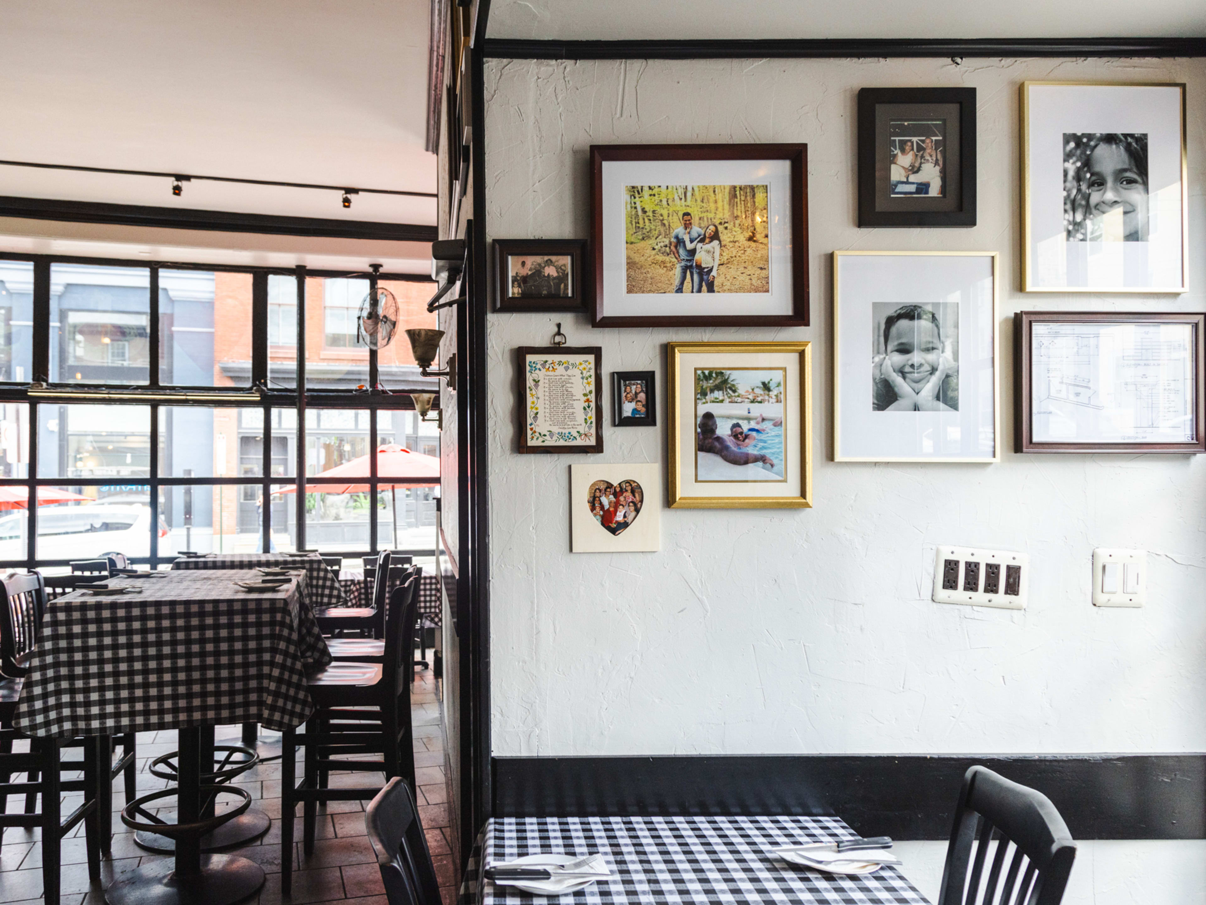 Bar Jawn has family photos on the wall and a dining room full of wood tables topped with tablecloths.