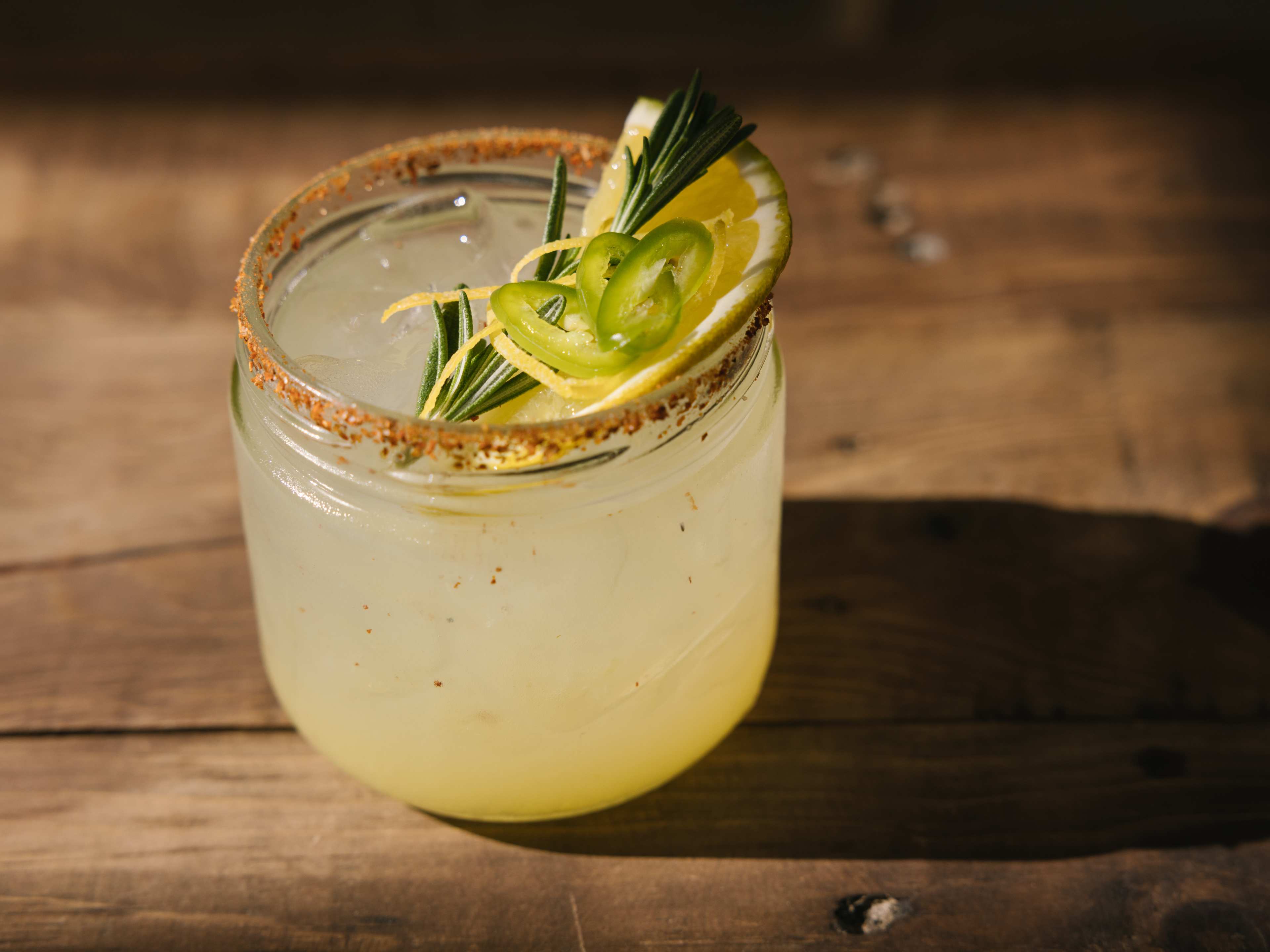 Spicy mezcal margarita garnished with lime and rosemary at Barracuda Cantina