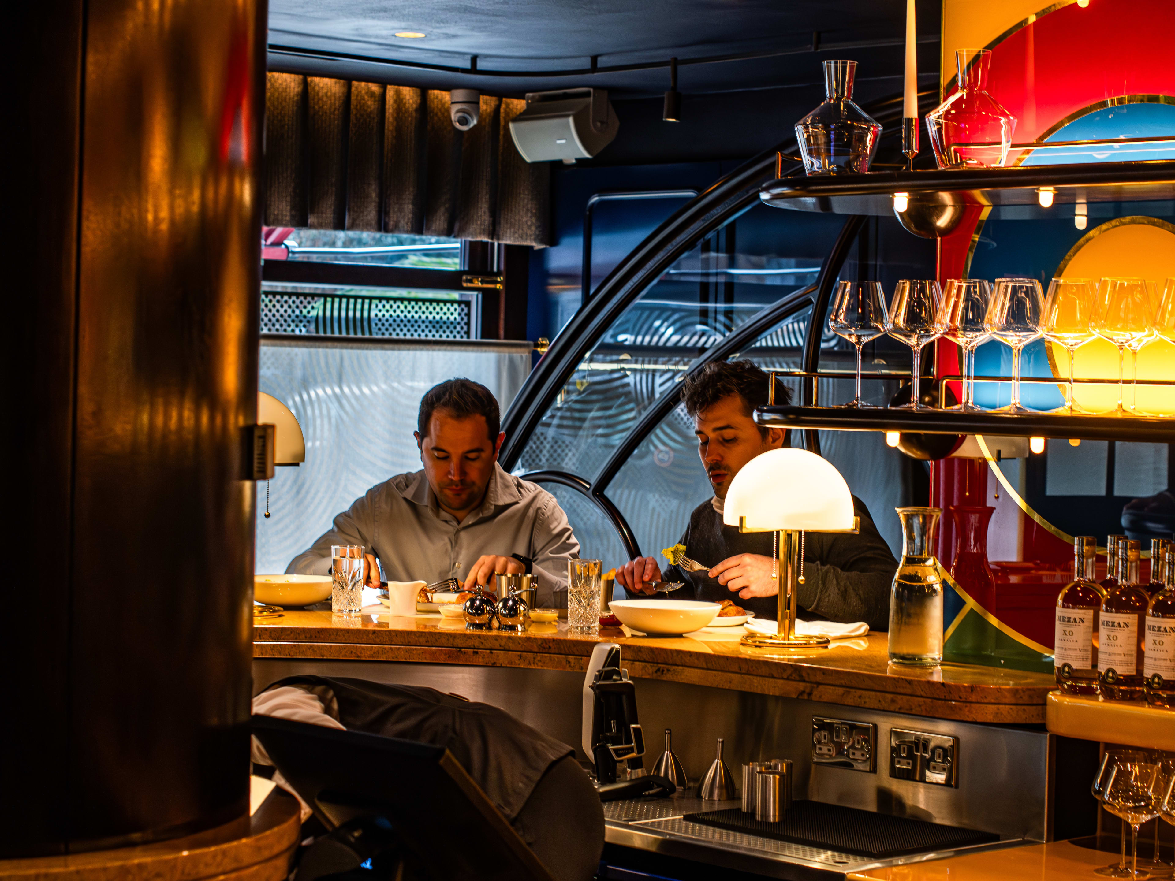 Two people eating a meal at the golden bar at Bebe Bob.