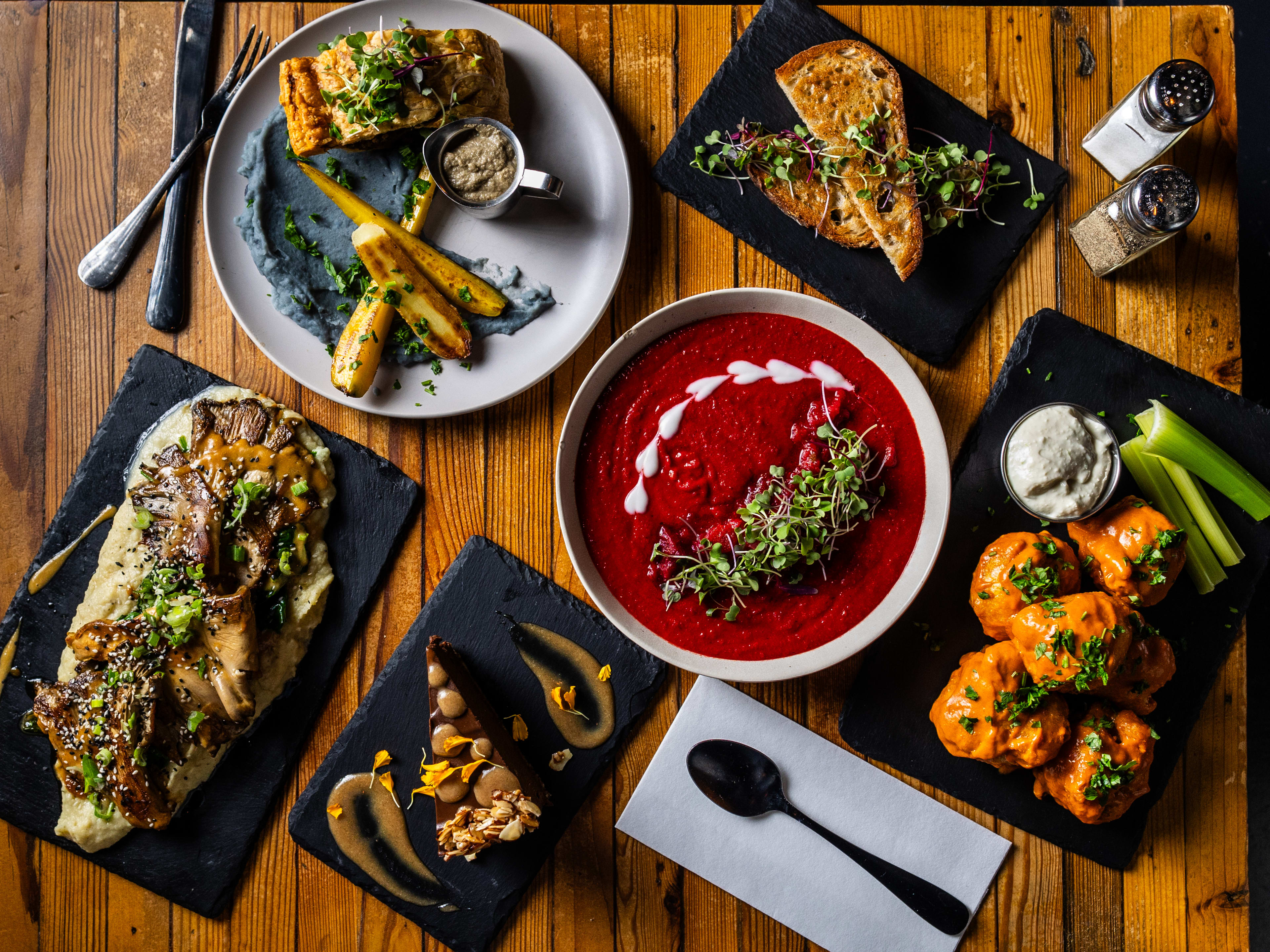 A spread of dishes on a wooden table at The Beer Plant.