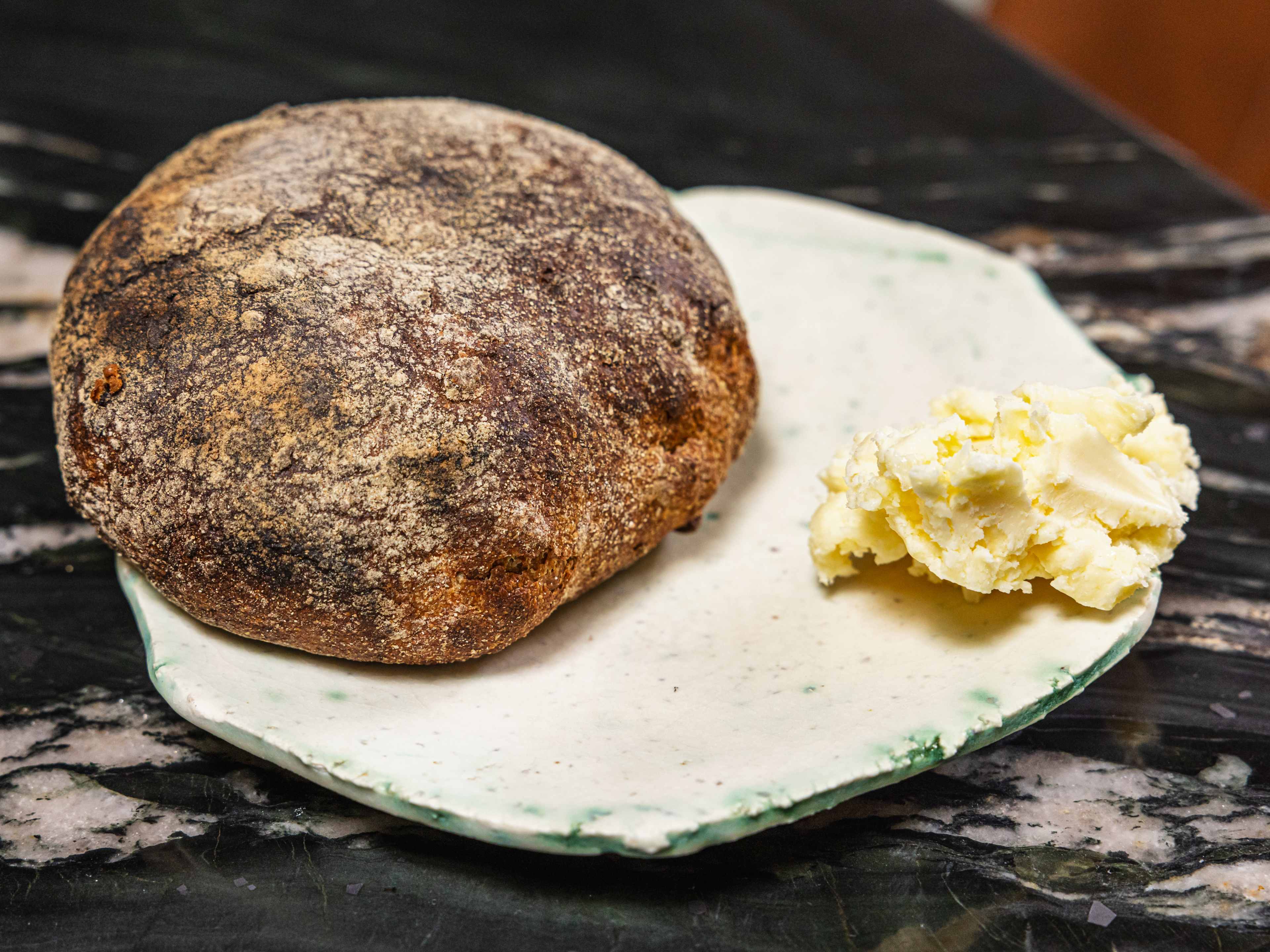 Tortilla al rescoldo and butter on a white stone platter.