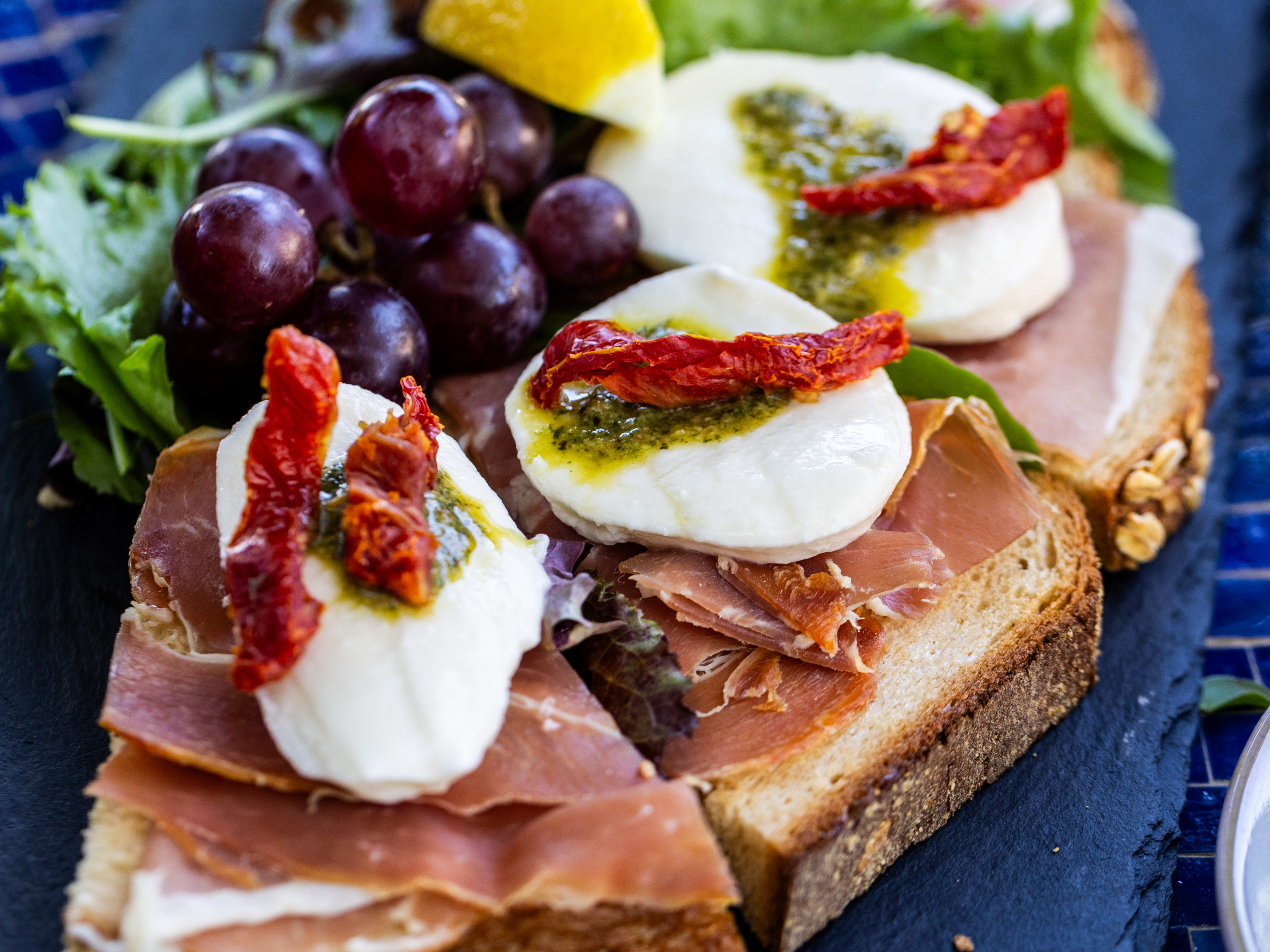 a tartine with prosciutto, mozzarella, and pesto