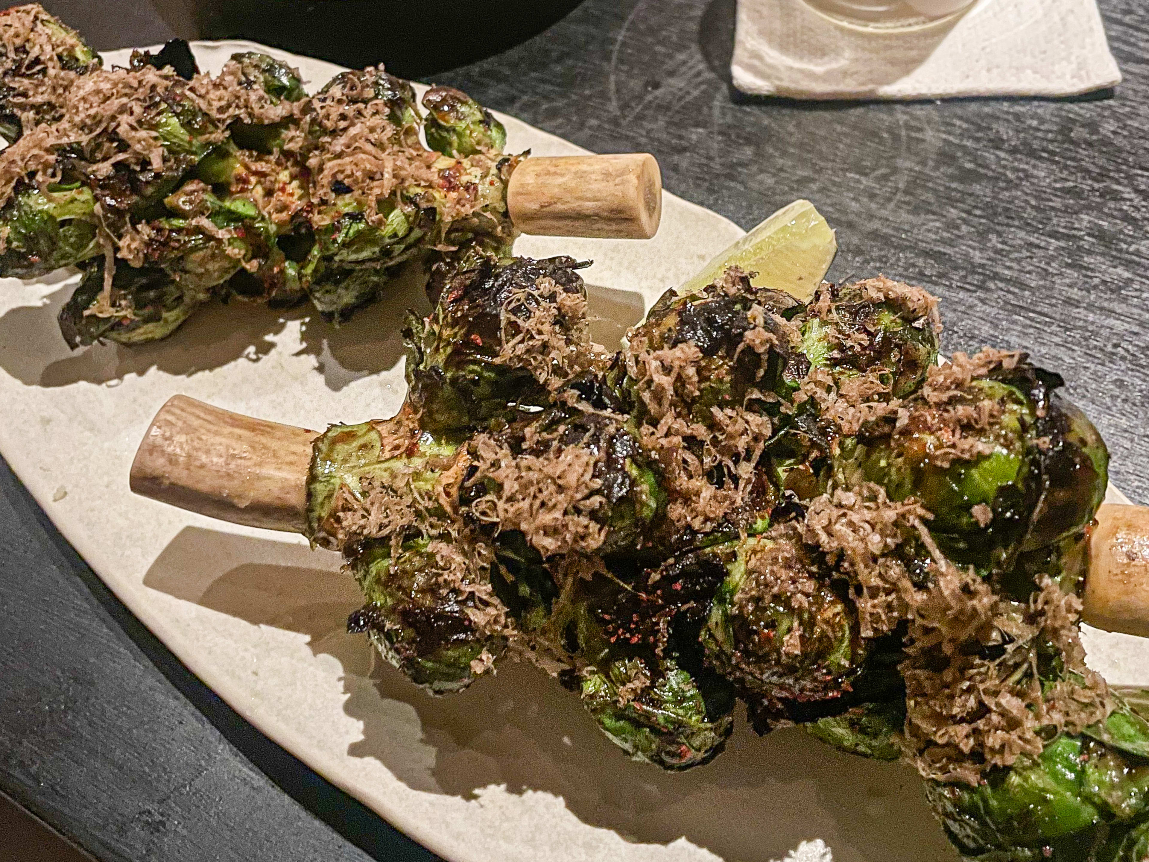 Brussels sprouts served on the stalk, with truffle shavings on top.