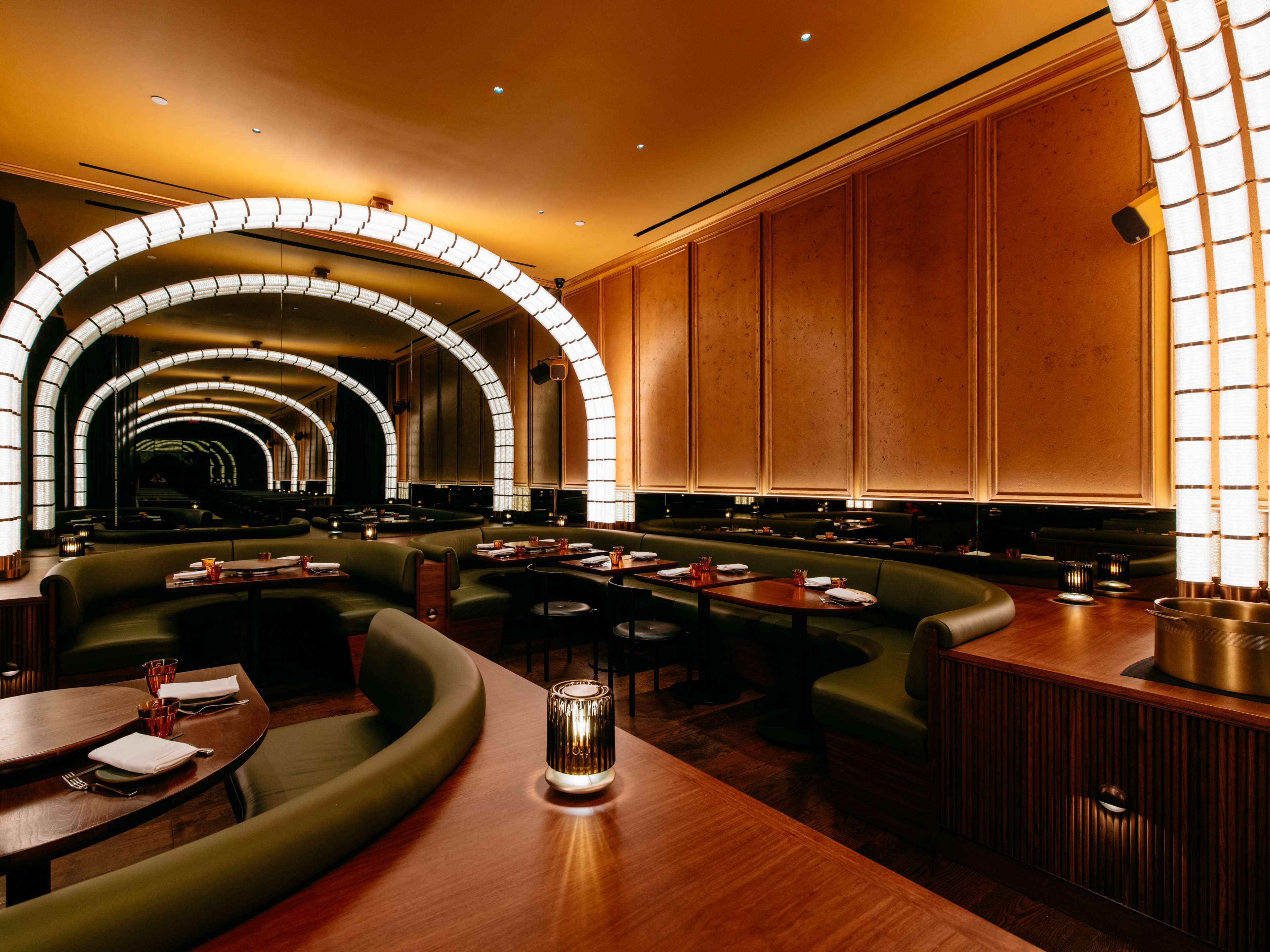 A modern dining room lined with glowing arches.