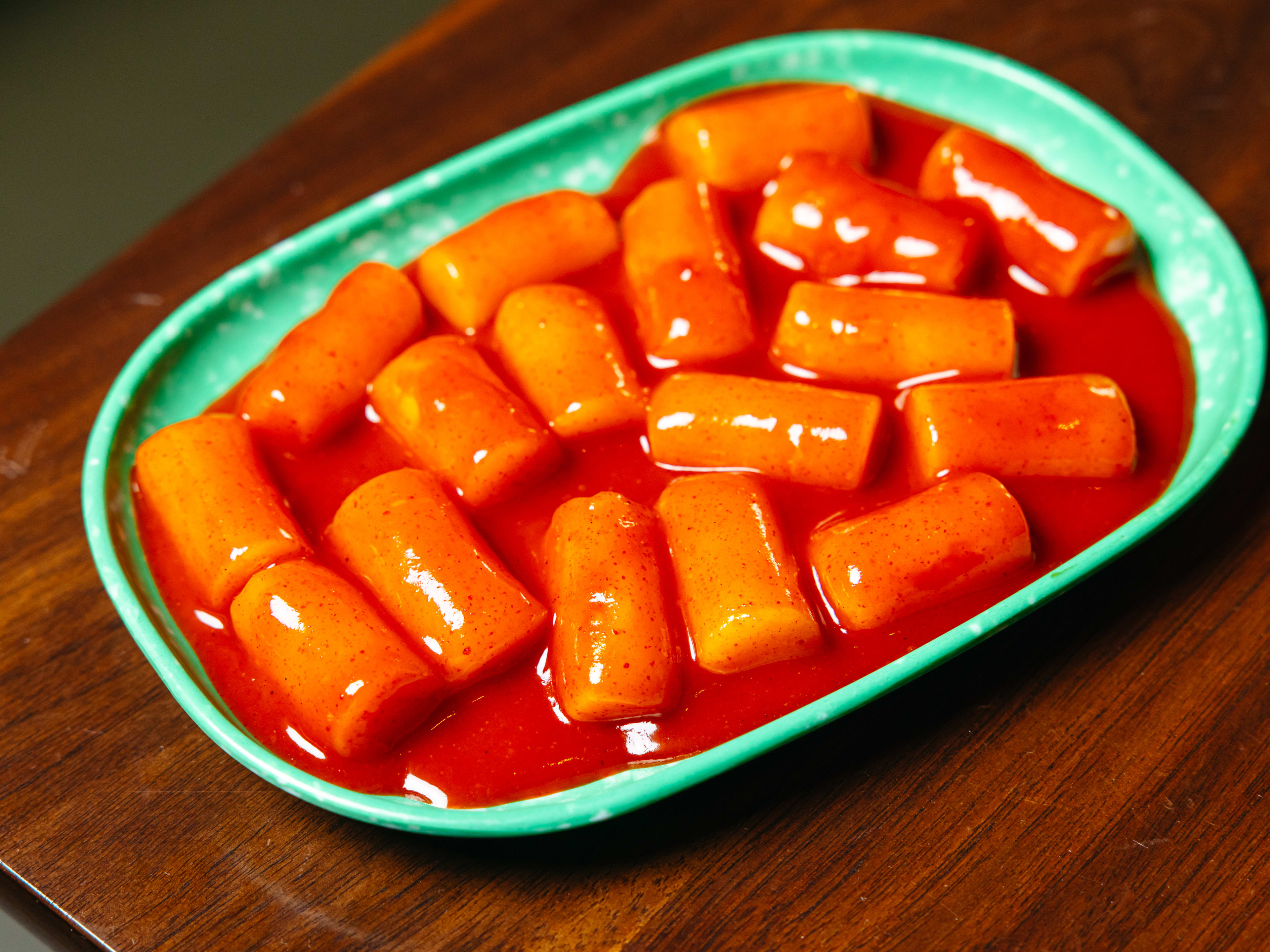 Spicy rice cakes in a green dish.