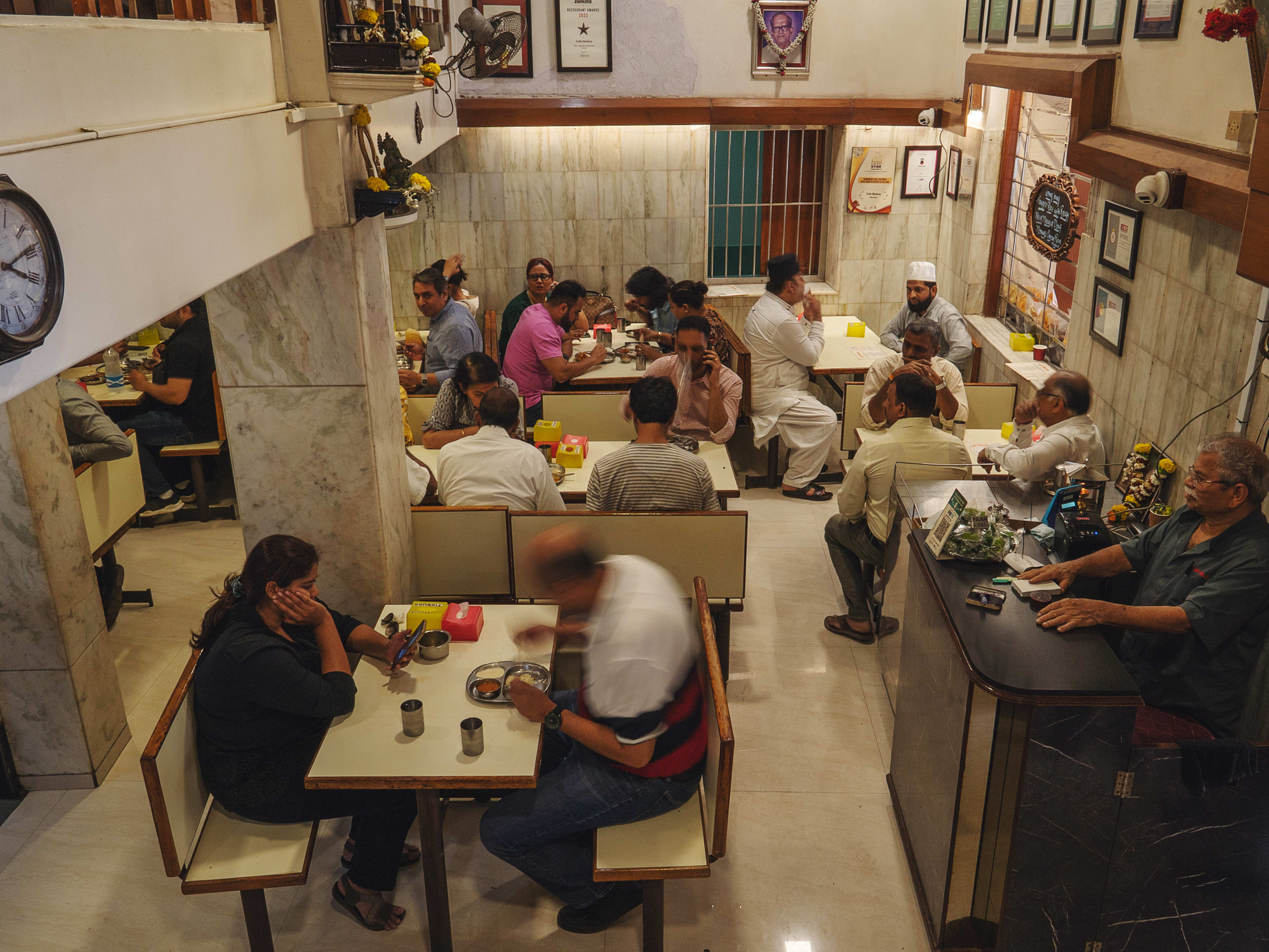 Crowded interior dining room with marbled walls at cafe Madras