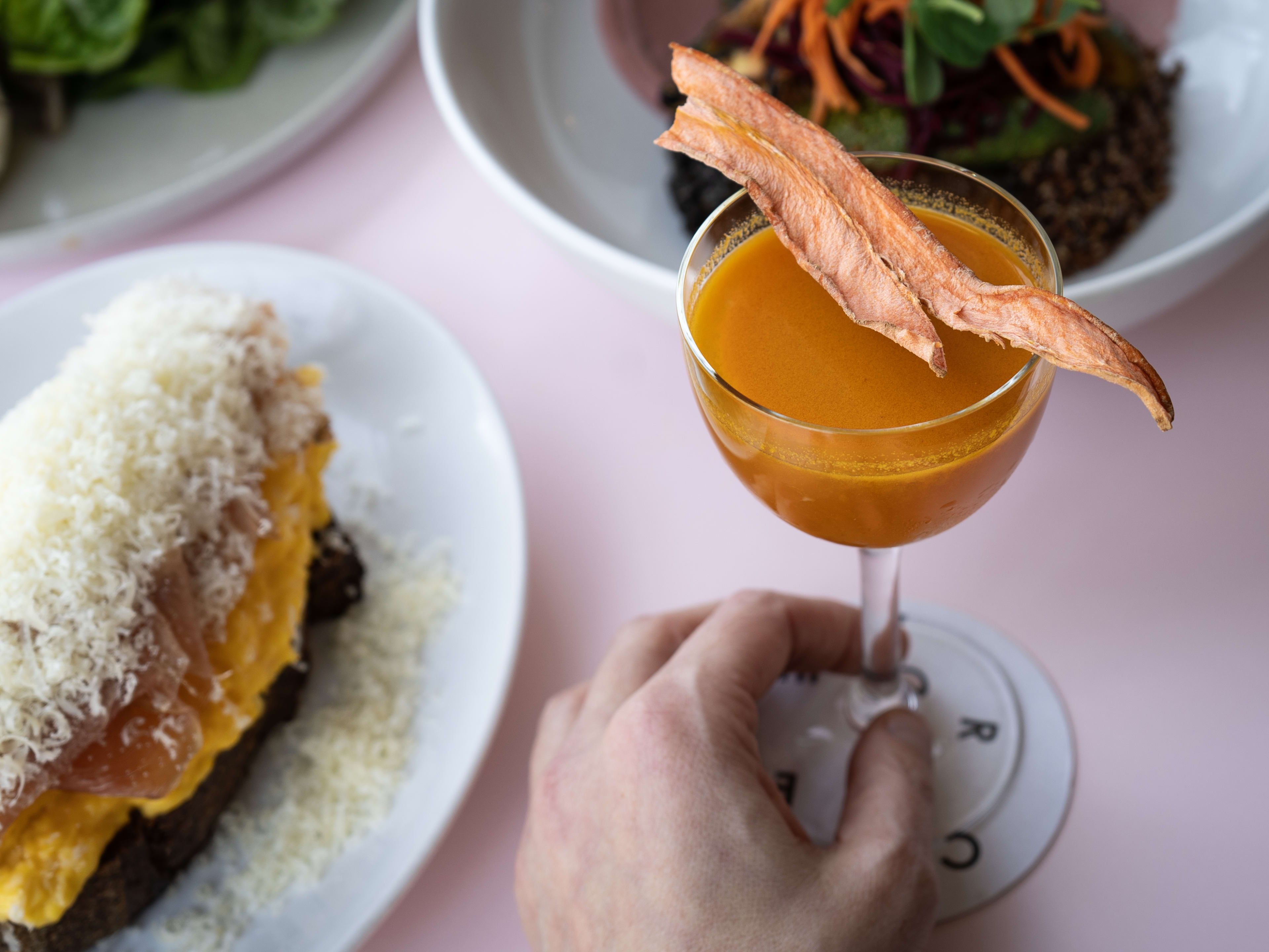 Carrot cocktail and spread of brunch dishes at Cafe Roze