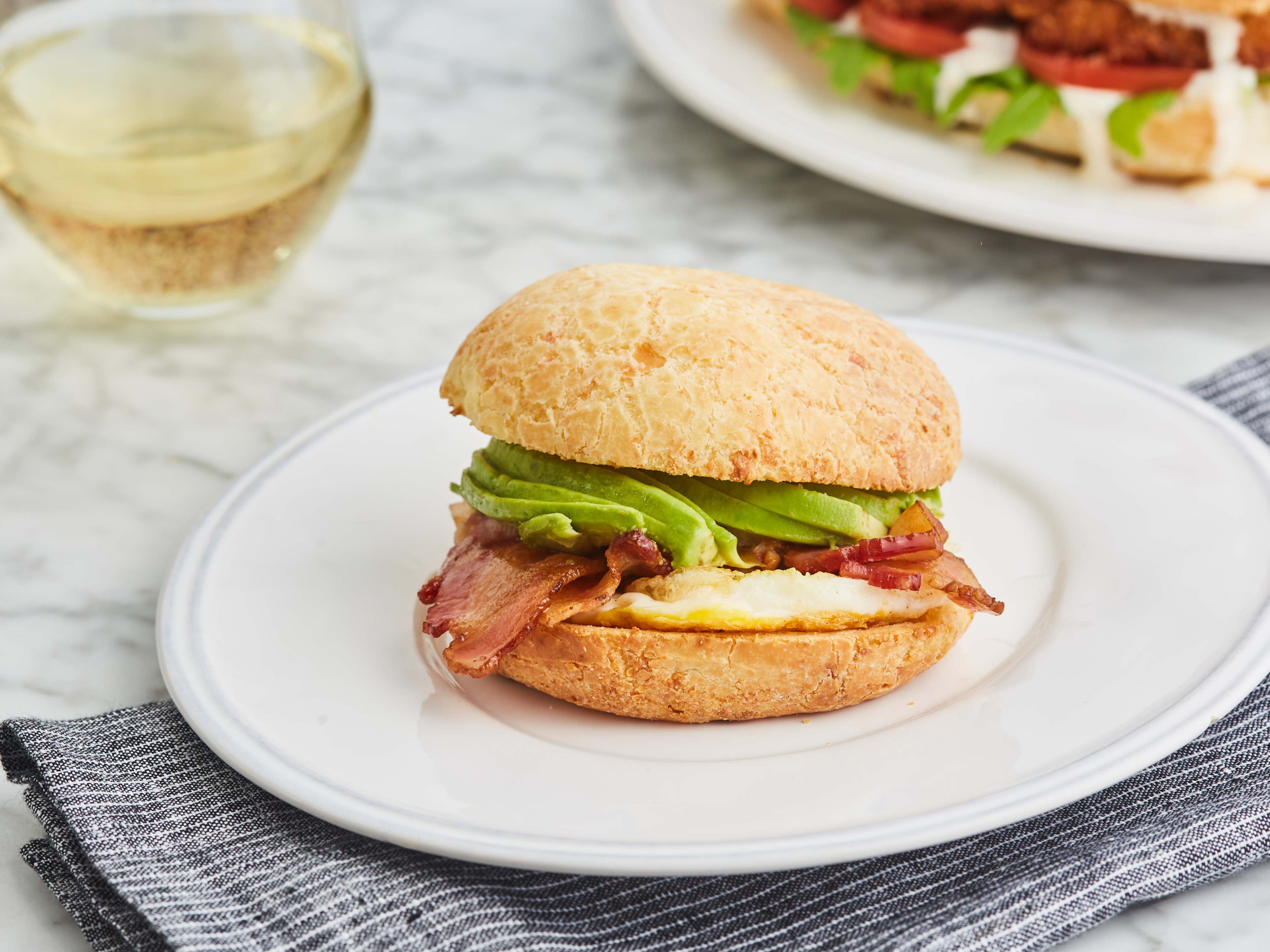 breakfast sandwich with avocado, ham, and egg