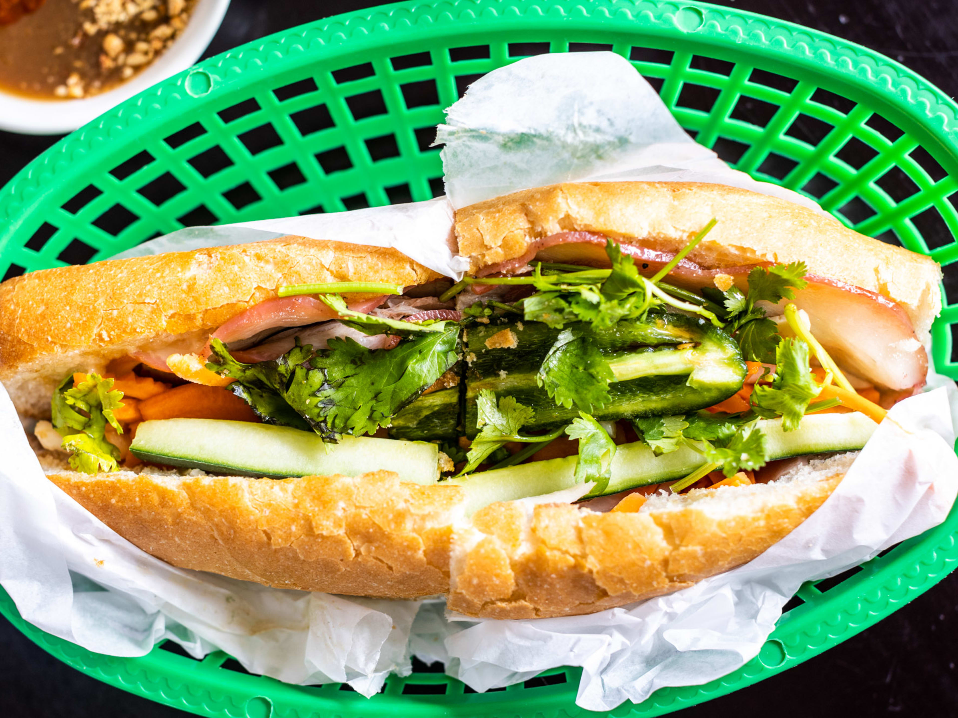 The Cali Combination banh mi from Cali Sandwiches & Pho served in a green basket.