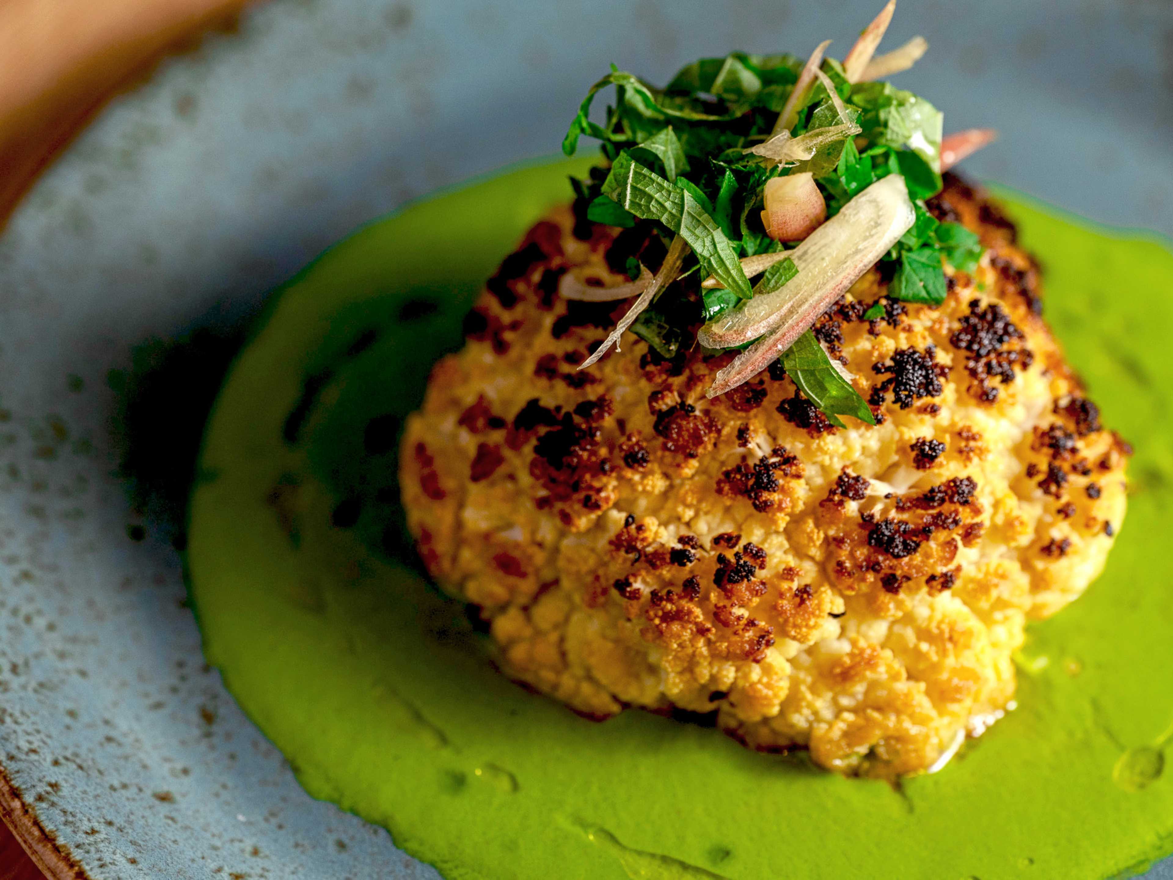 Roasted cauliflower on top of a green sauce