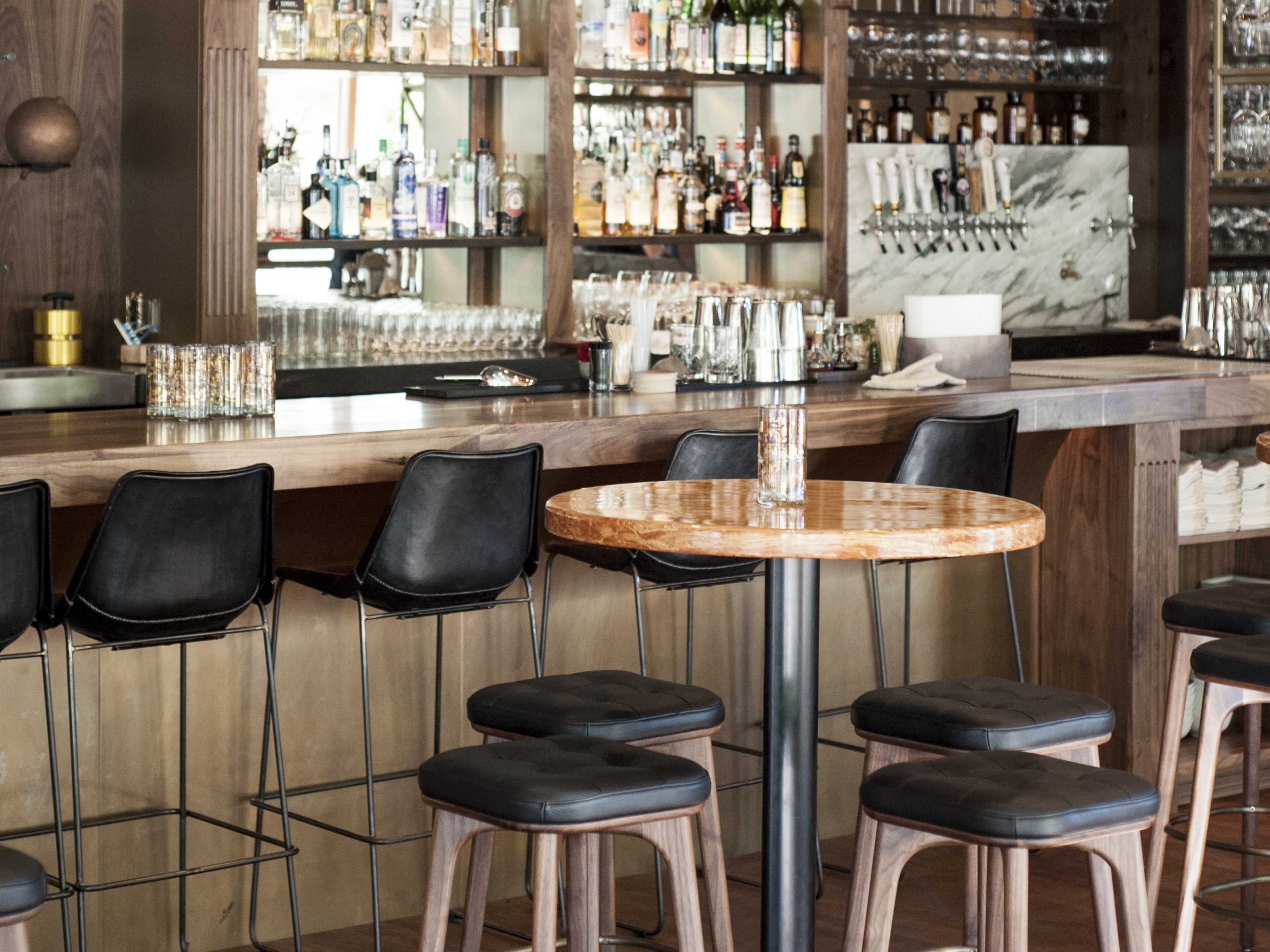 A bar and a high top table inside Chambar, a restaurant in Vancouver