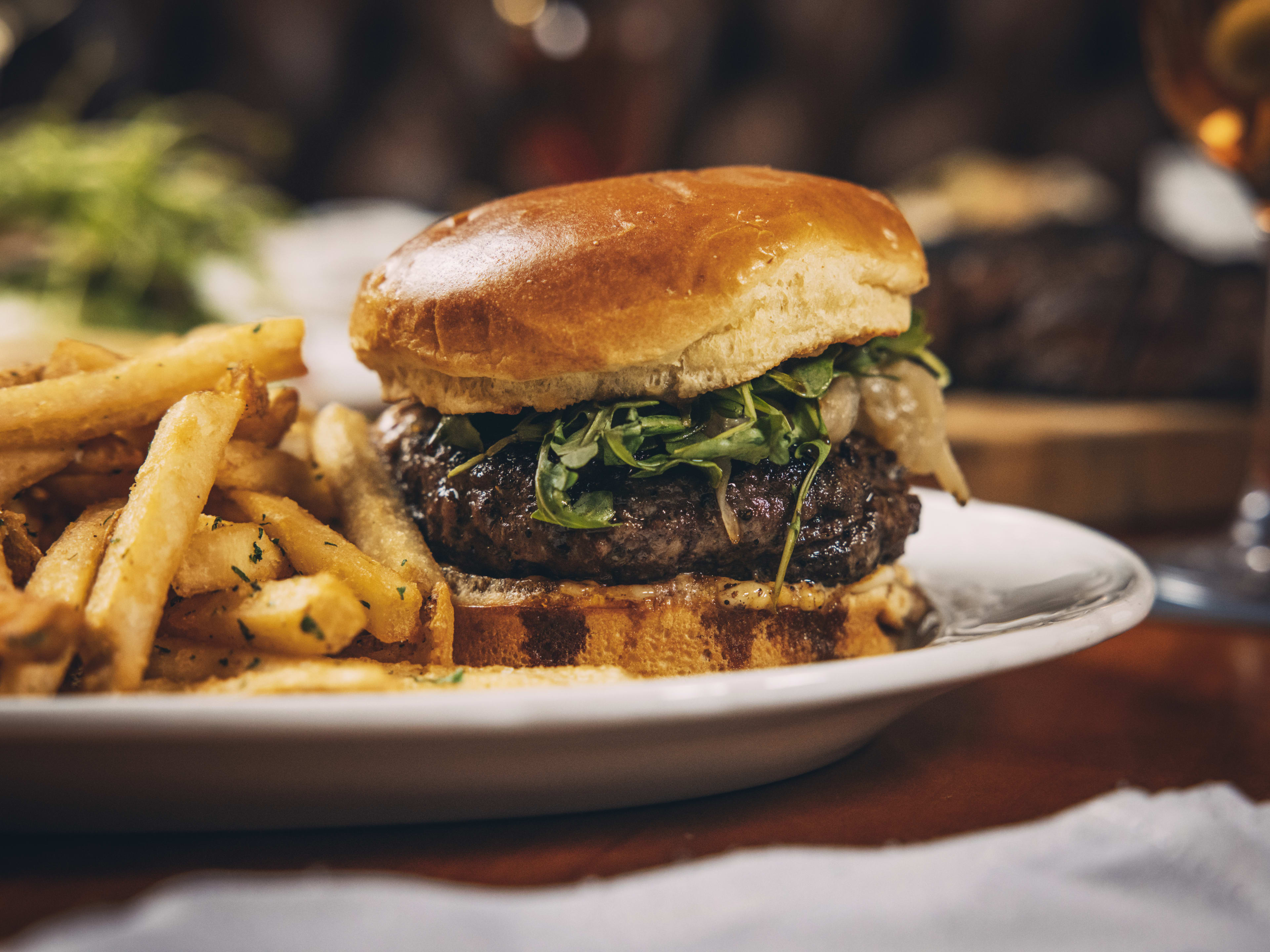 Thick burger with fries next to it