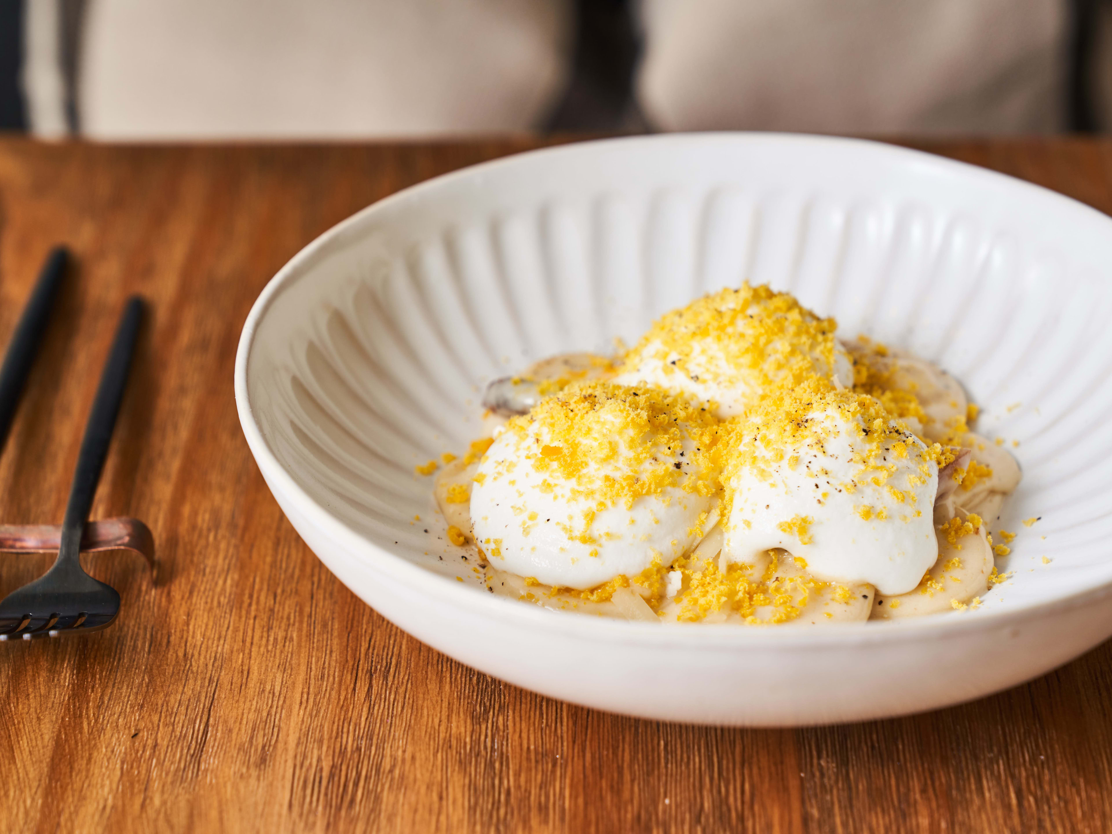 big ravioli with shaved egg yolk on top