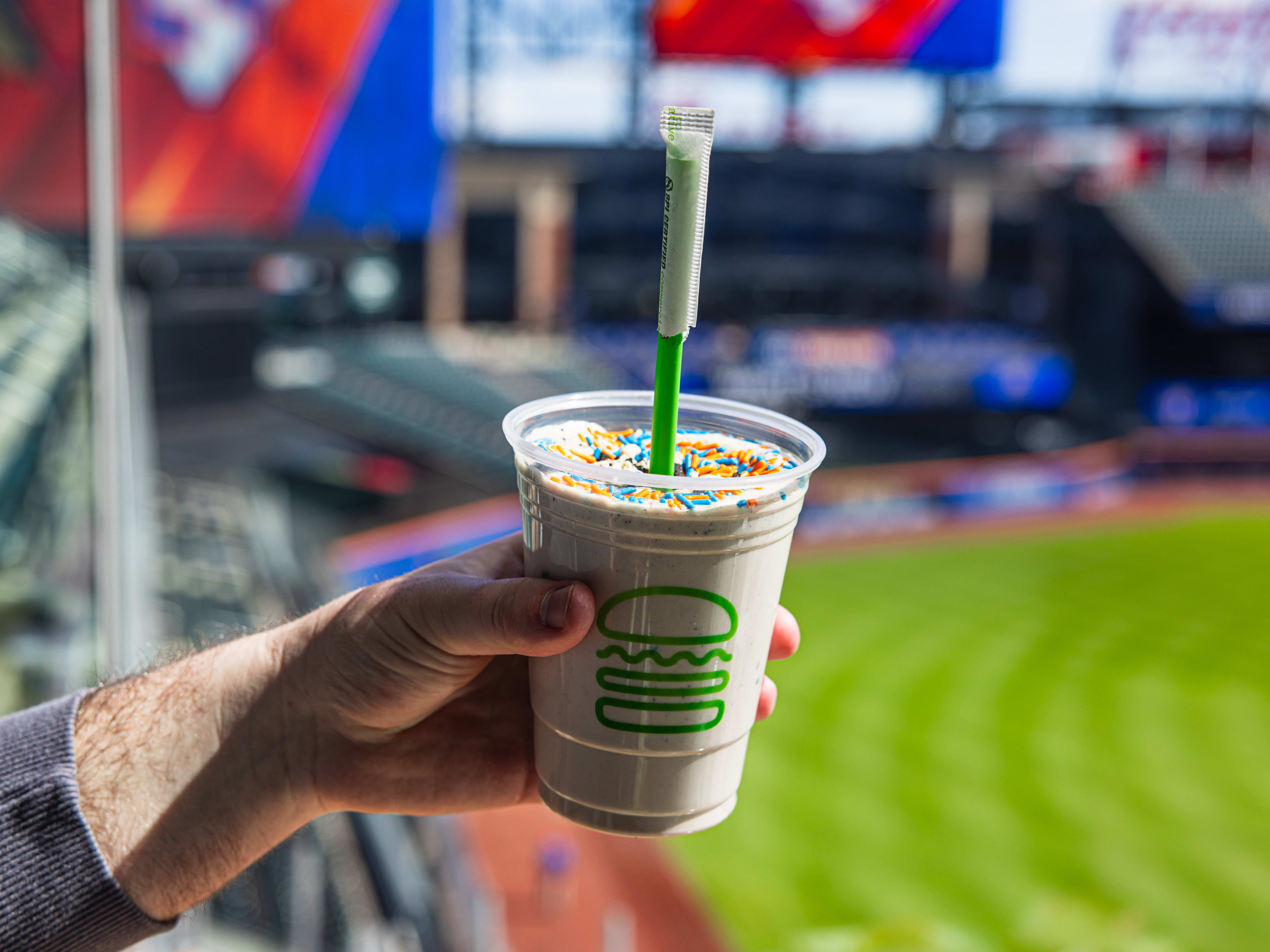 a chocolate shake from shake shack with orange and blue sprinkles