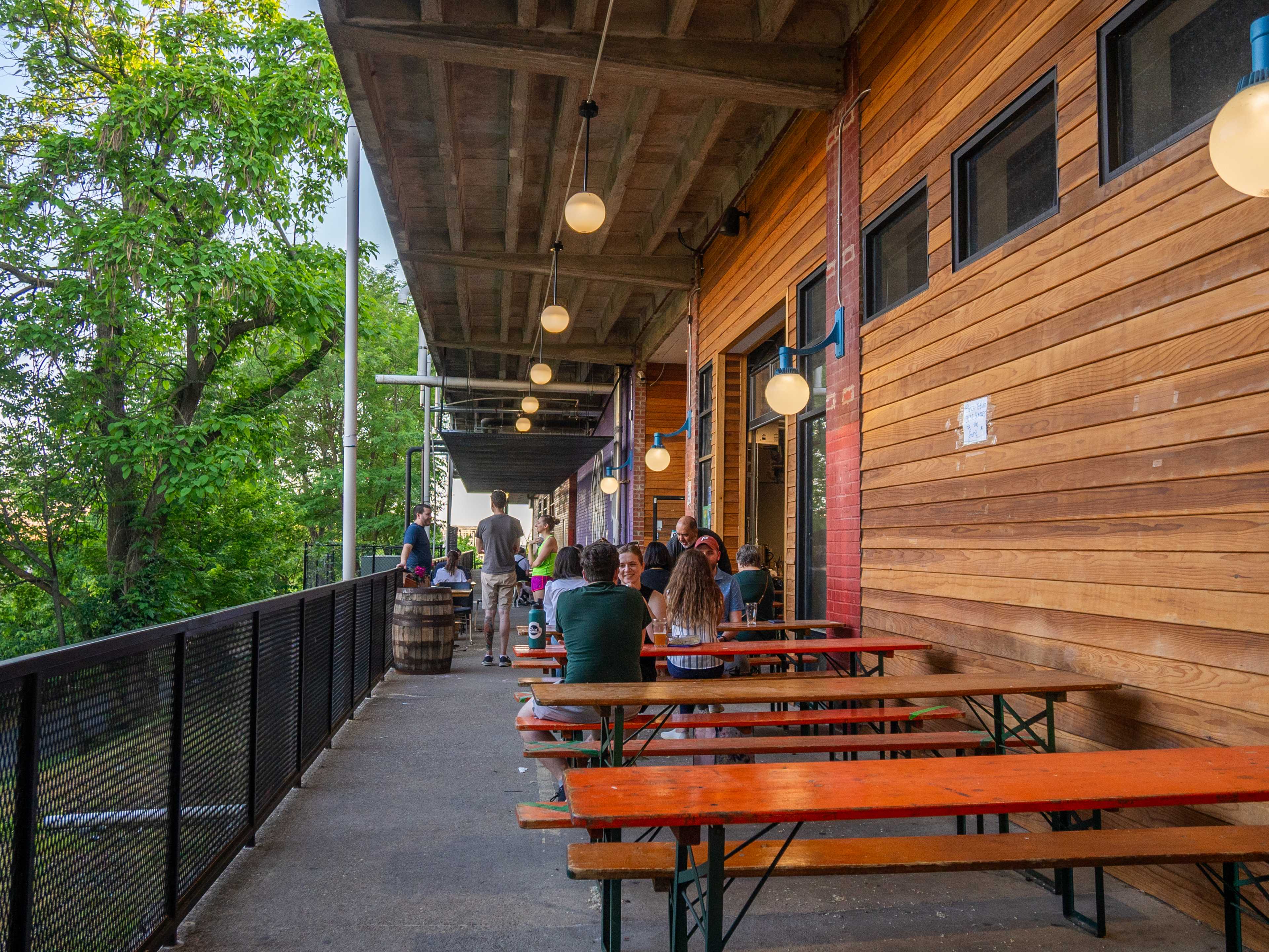 brewery patio with folks sitting at picnic tables and lots of surrounding trees