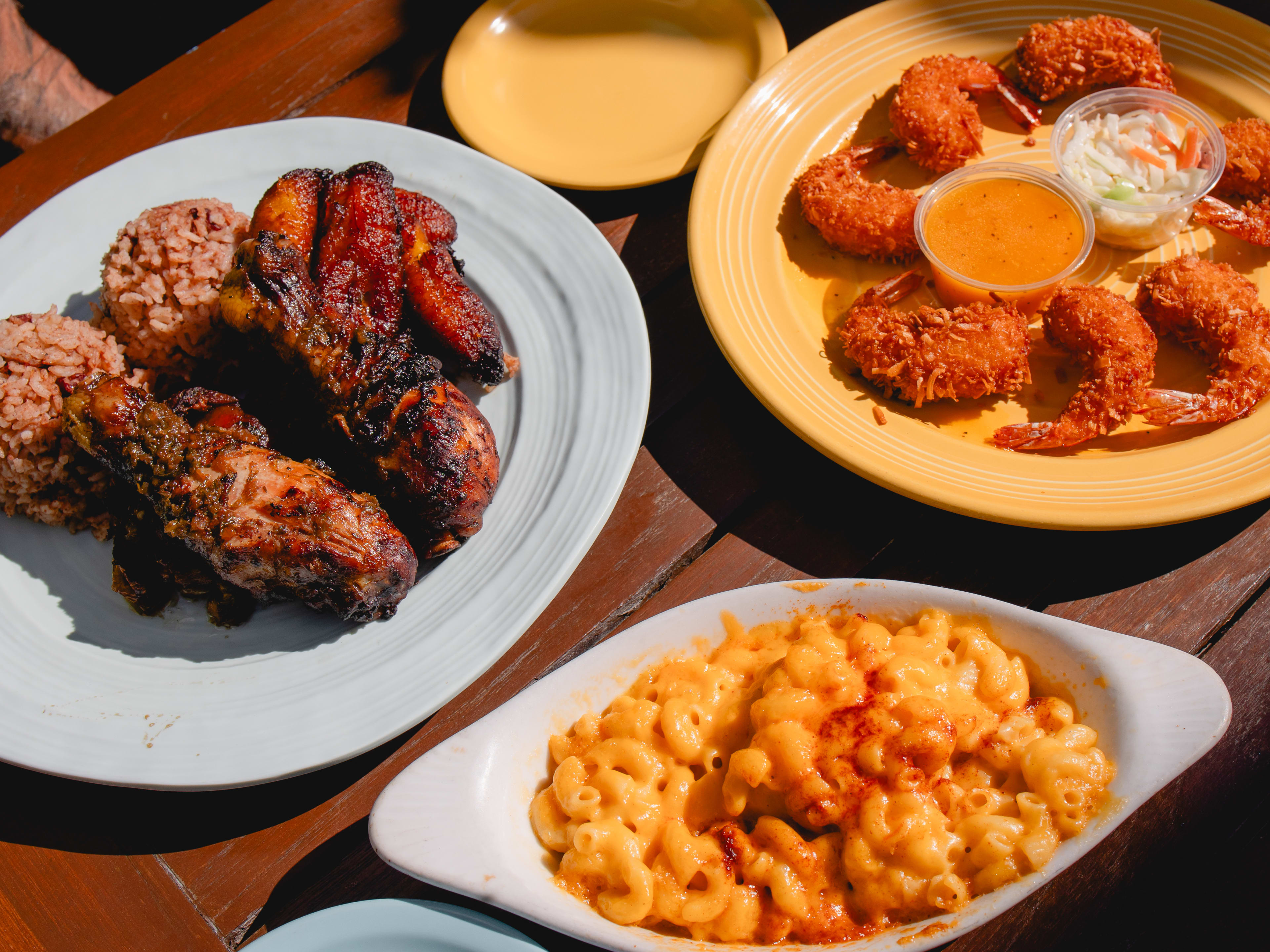 spread of jerk chicken, rice, mac and cheese, and coconut shrimp