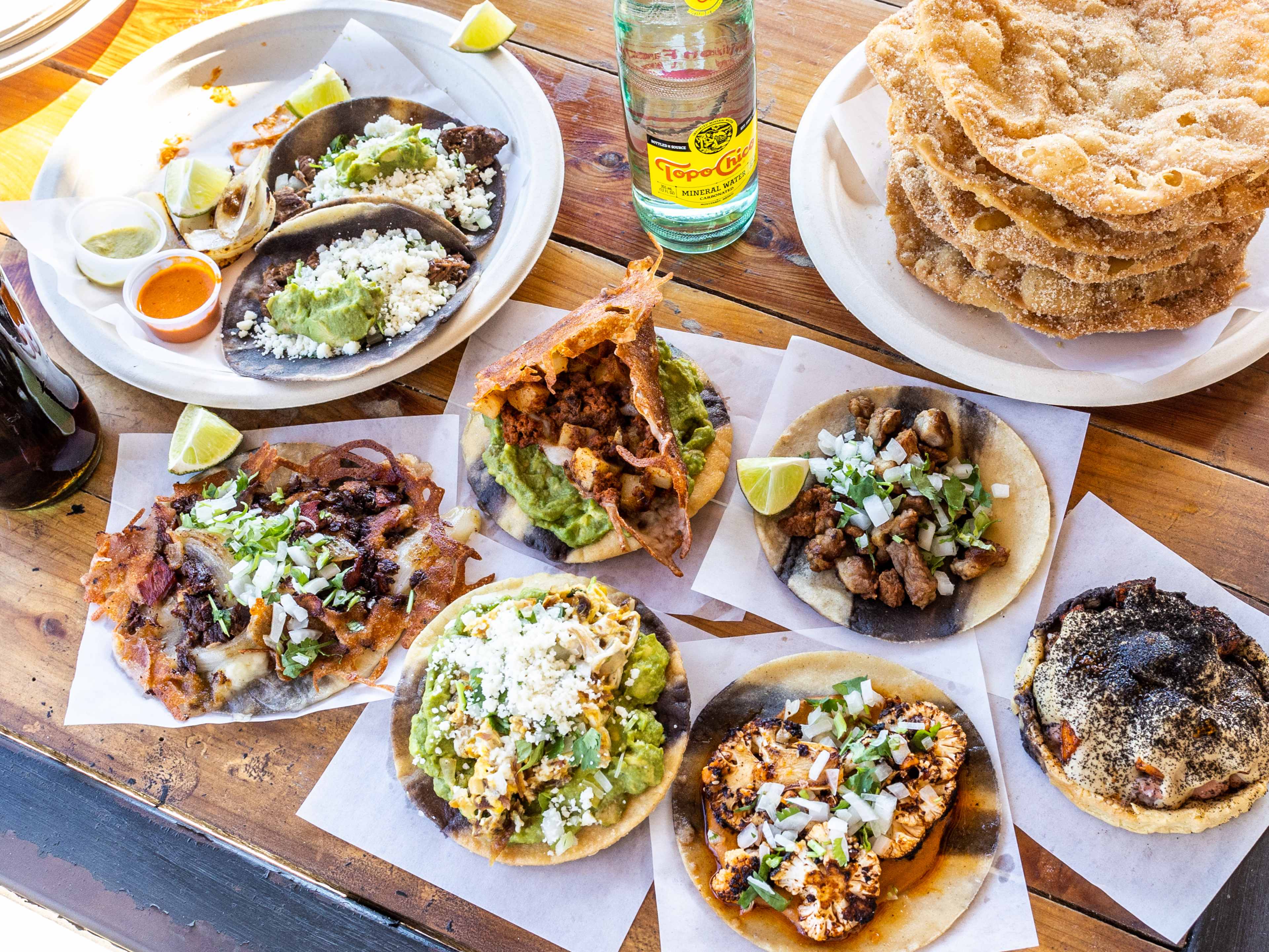 A spread of dishes on a wooden table at Con Todo.