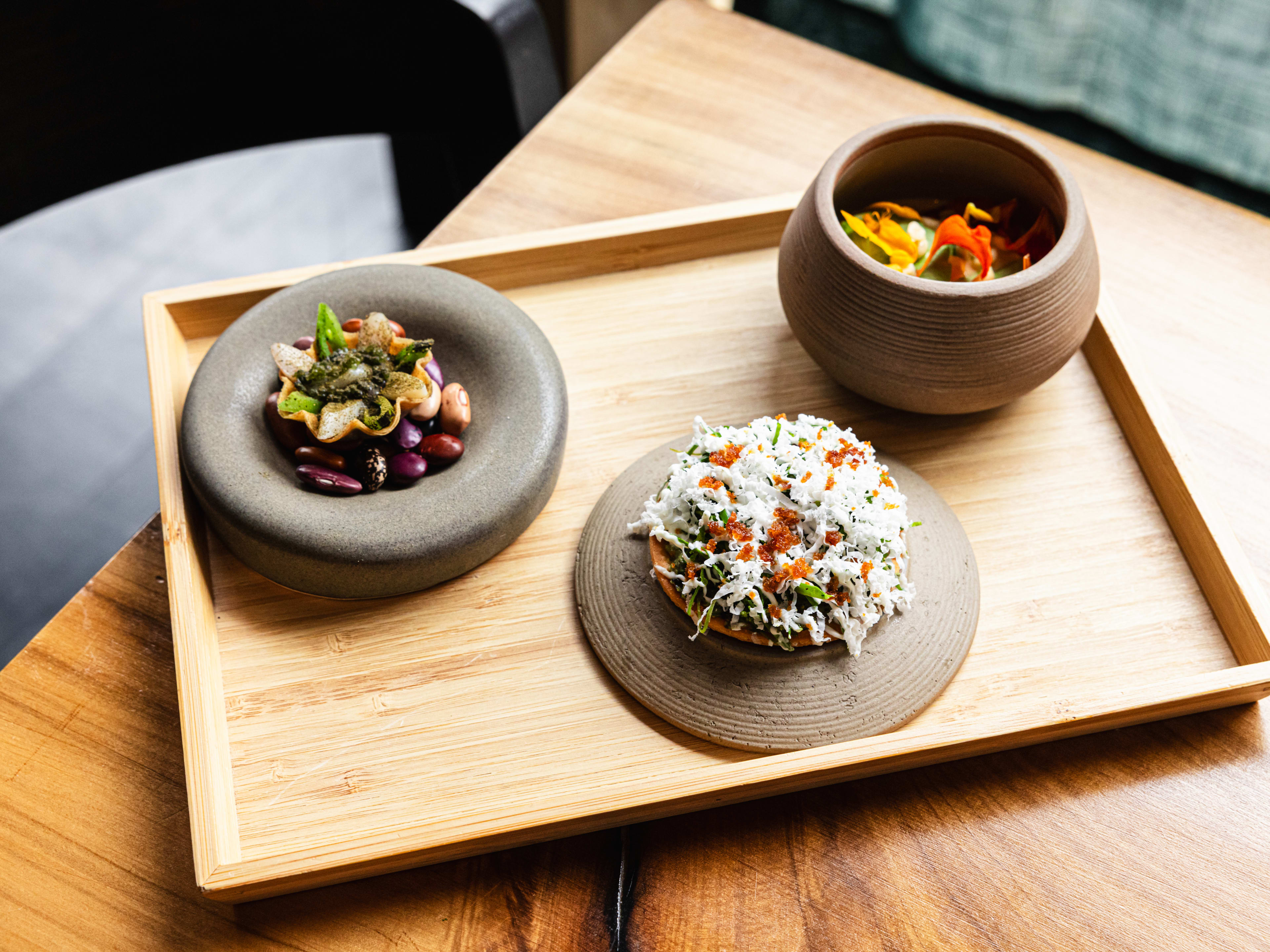 A few fancy snacks served on earth-toned ceramics.