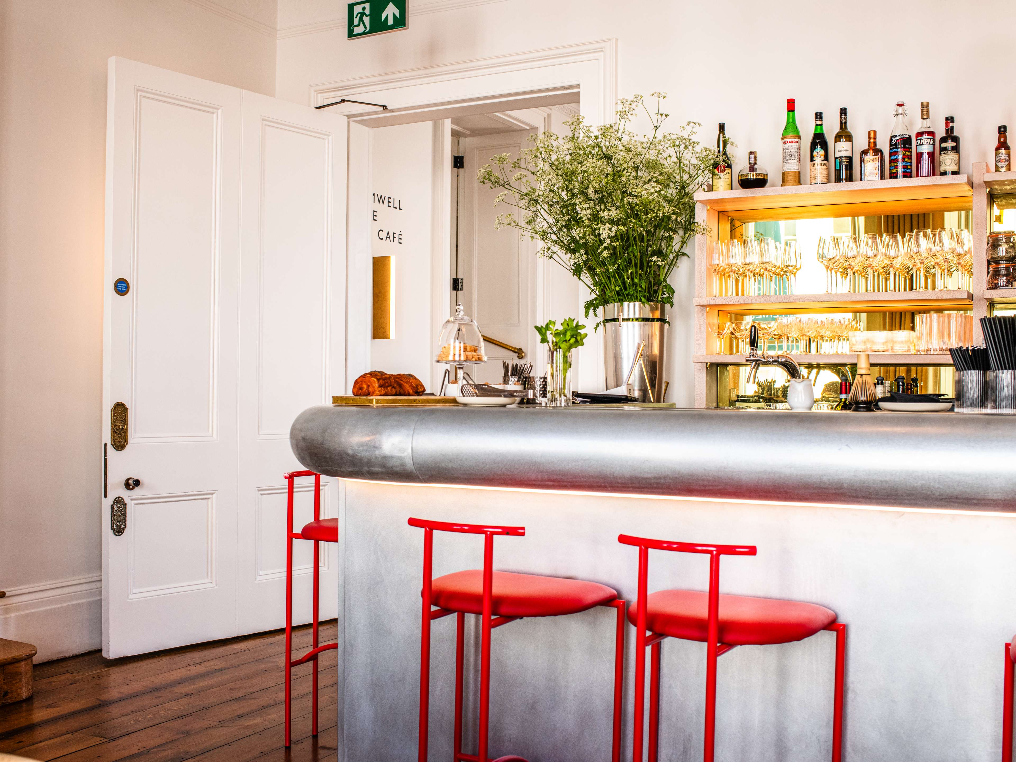 A bright white bar area with red stools.