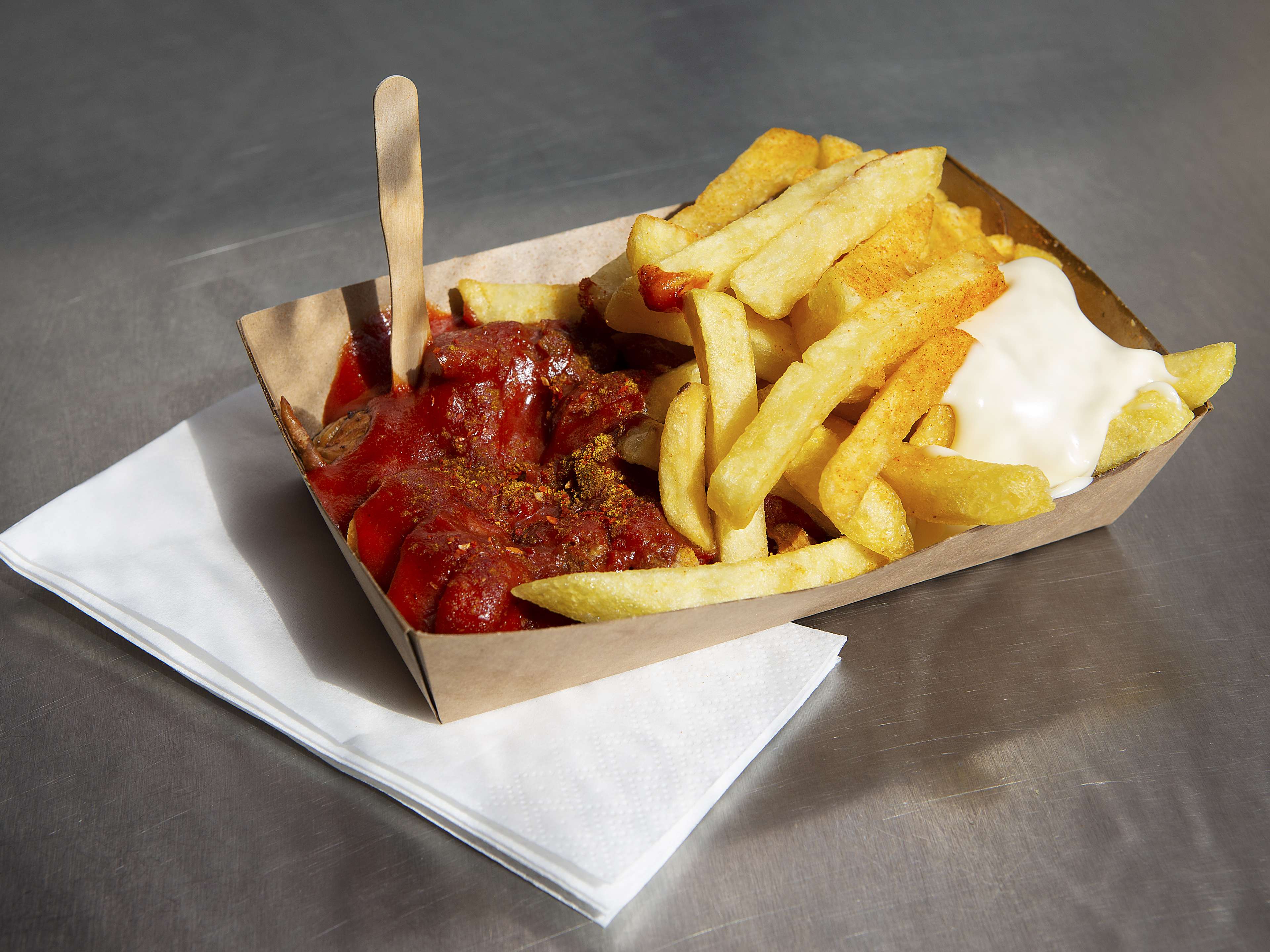 Currywurst and fries served in takeout container at Curry 61