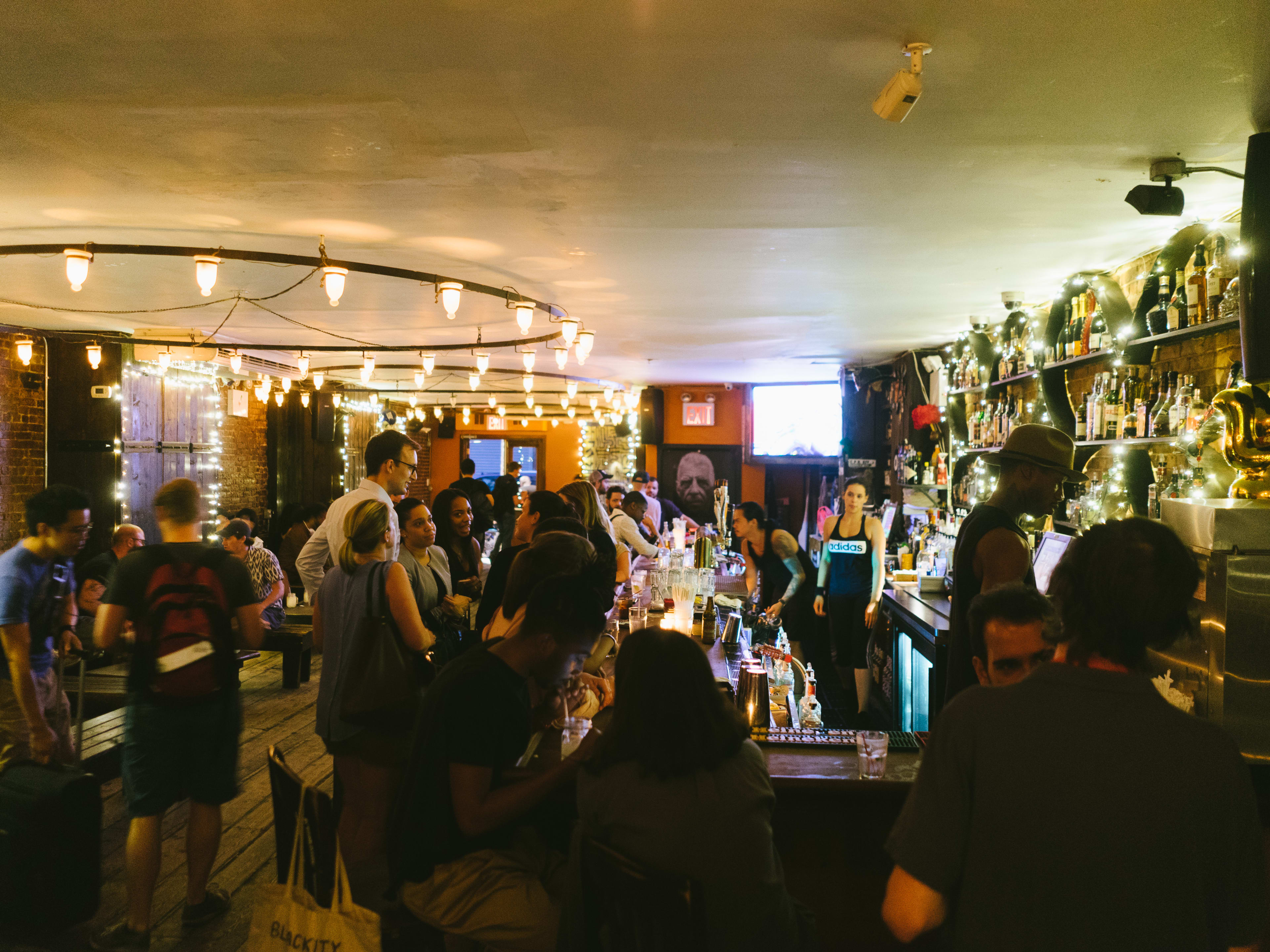 A crowded dive bar with lots of lights on the ceiling.