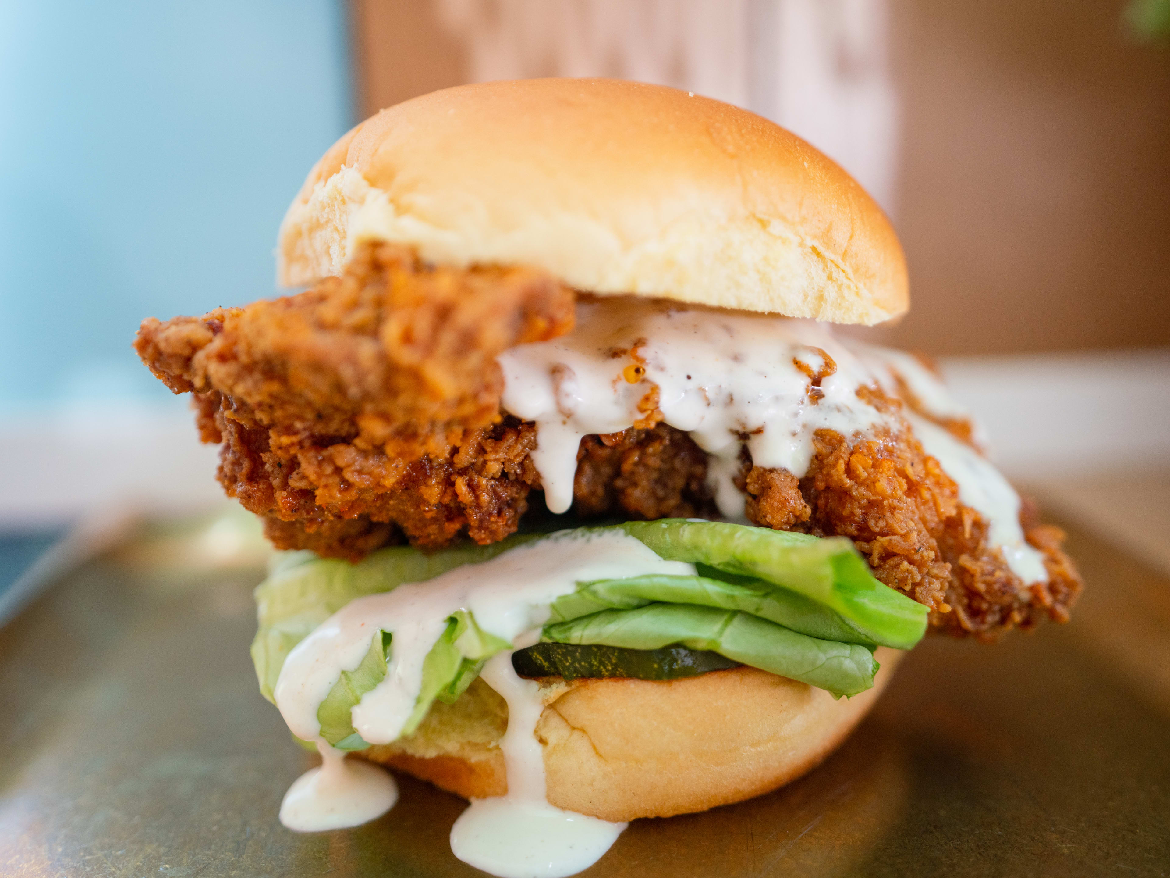 The fried chicken sandwich from Chick Chick served on a metal tray.