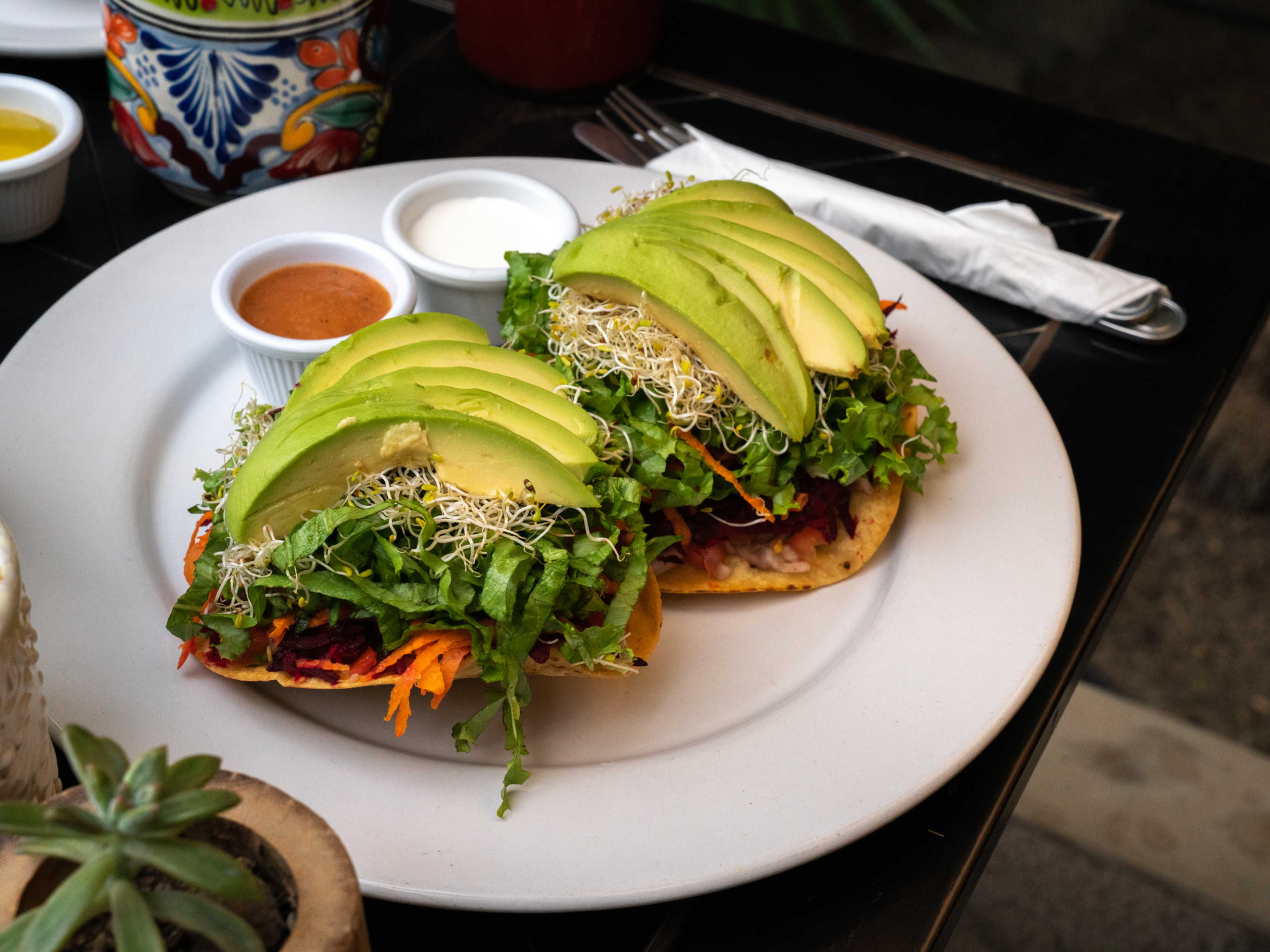 Veggie tostadas topped with avocado at La Esquina