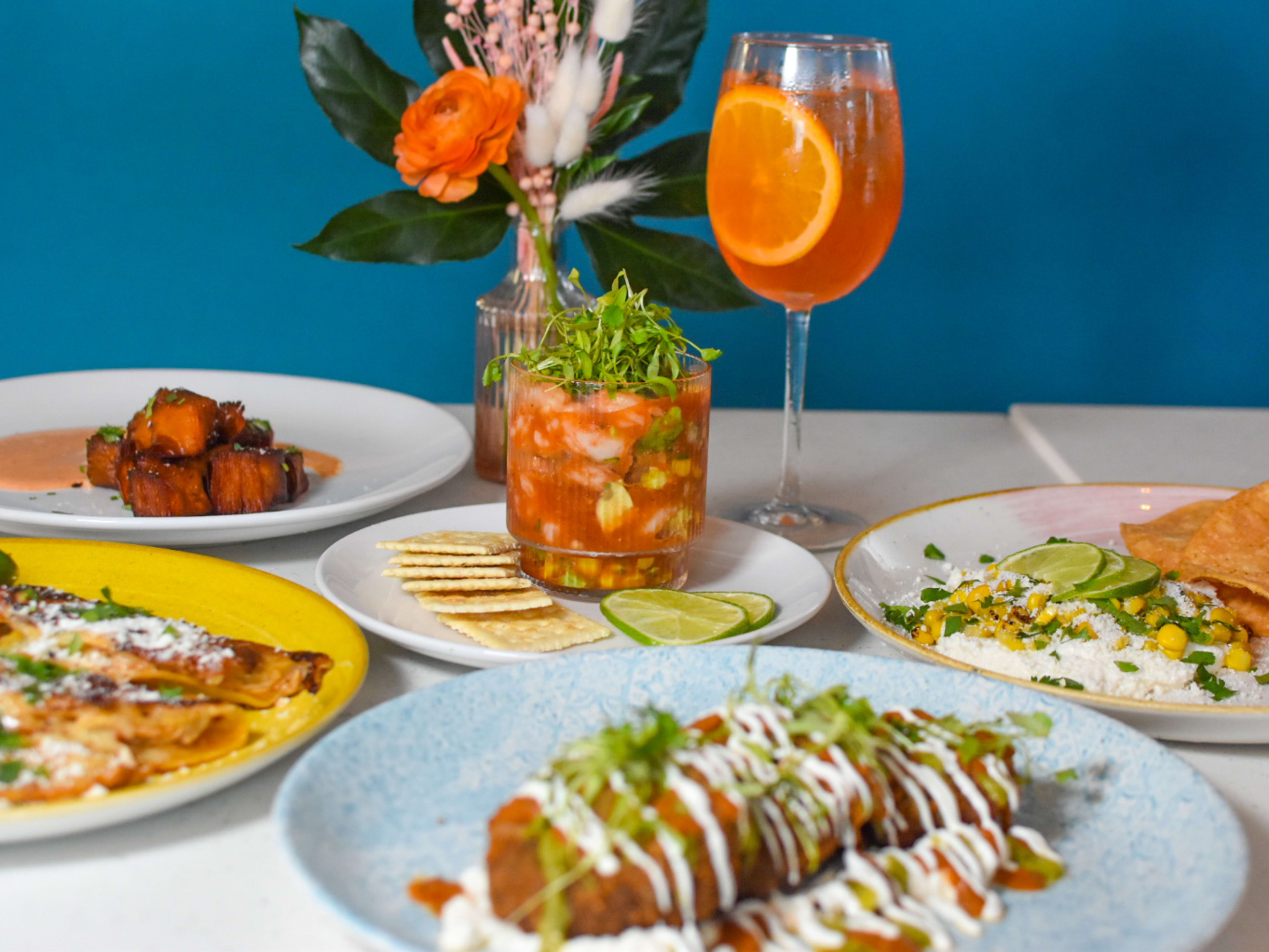 spread of dishes including ceviche, quesadillas, corn, and a spritz