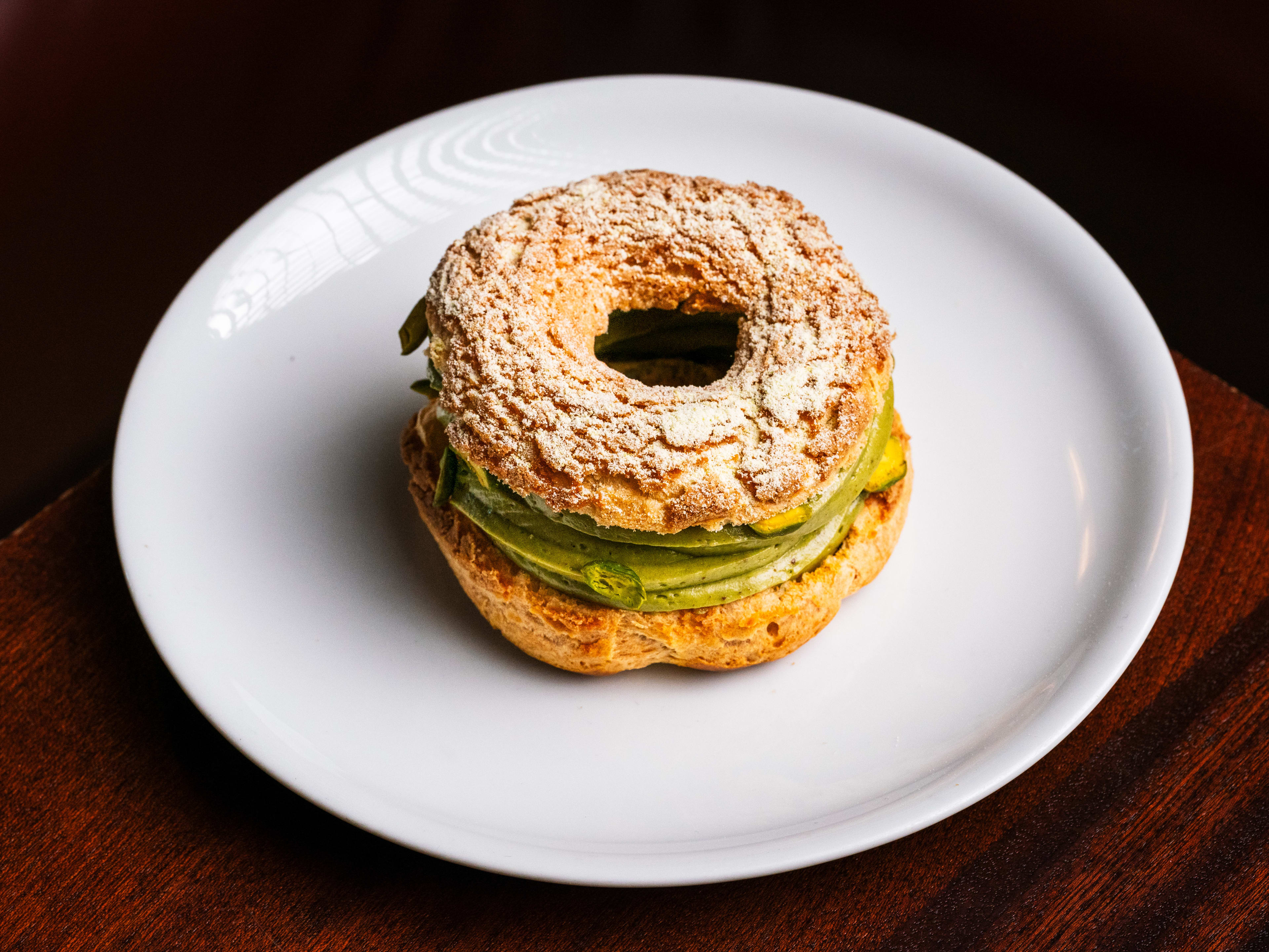 A round French pastry filled with pale green pistachio cream.