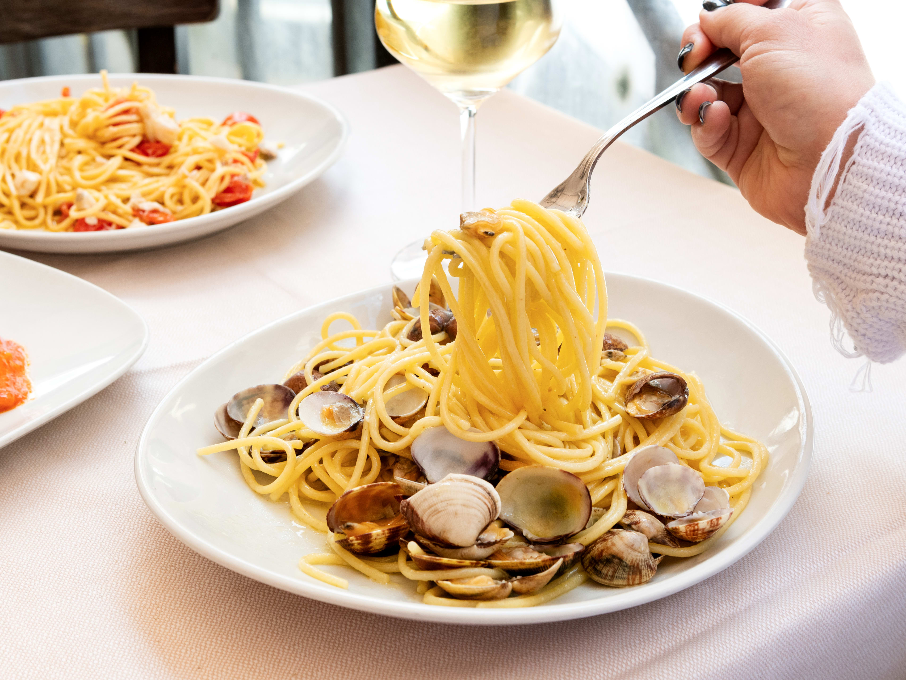 Woman eating spaghetti all vongole at Osteria Der Belli