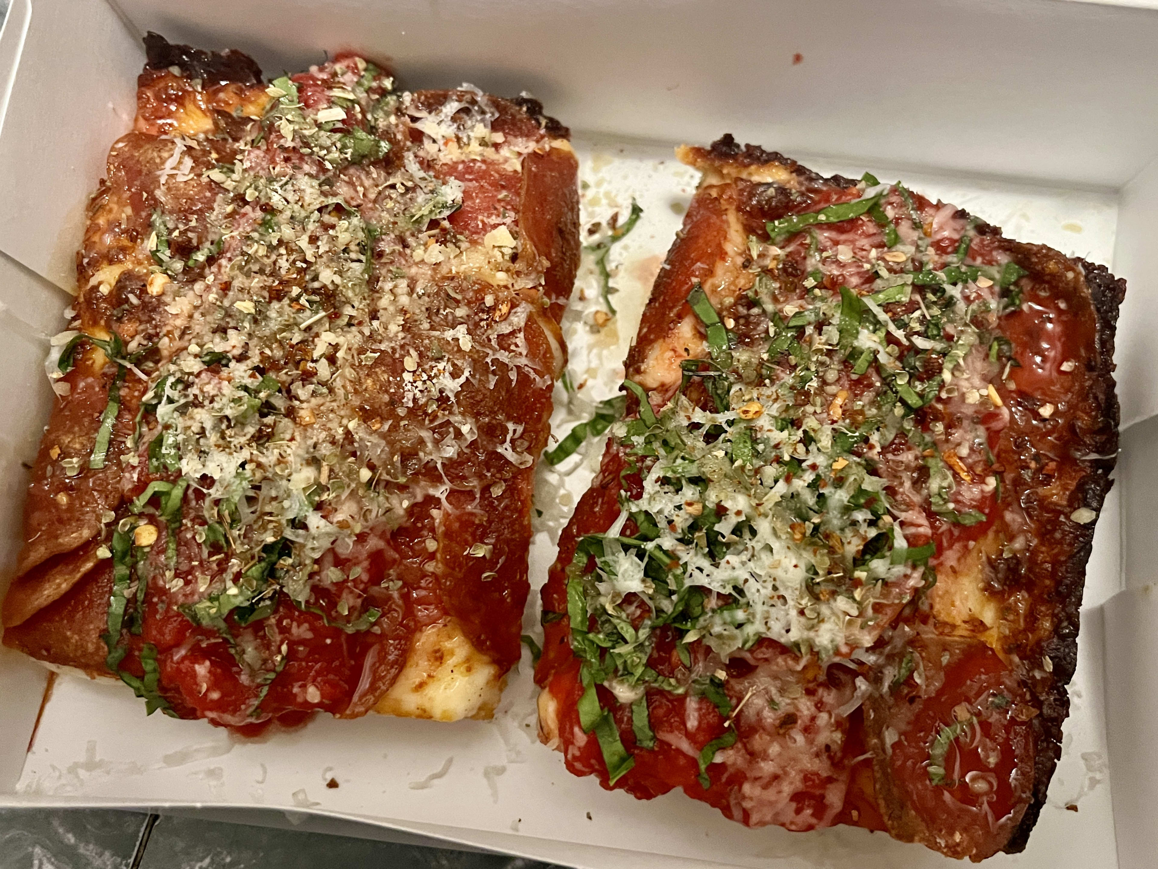 Two slices of pizza from Detroit Square Pizza in San Francisco.