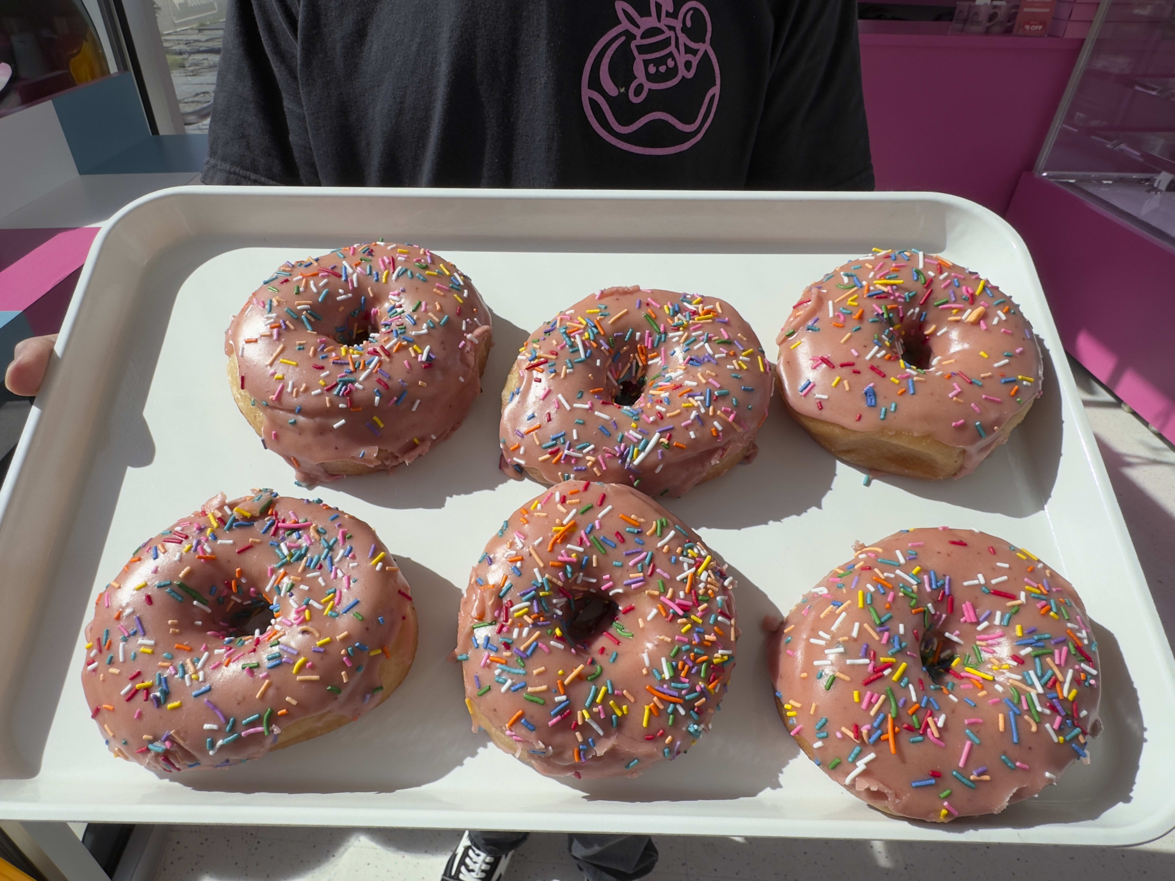 A plate of pink sprinkled donuts from Dreamboat Donuts