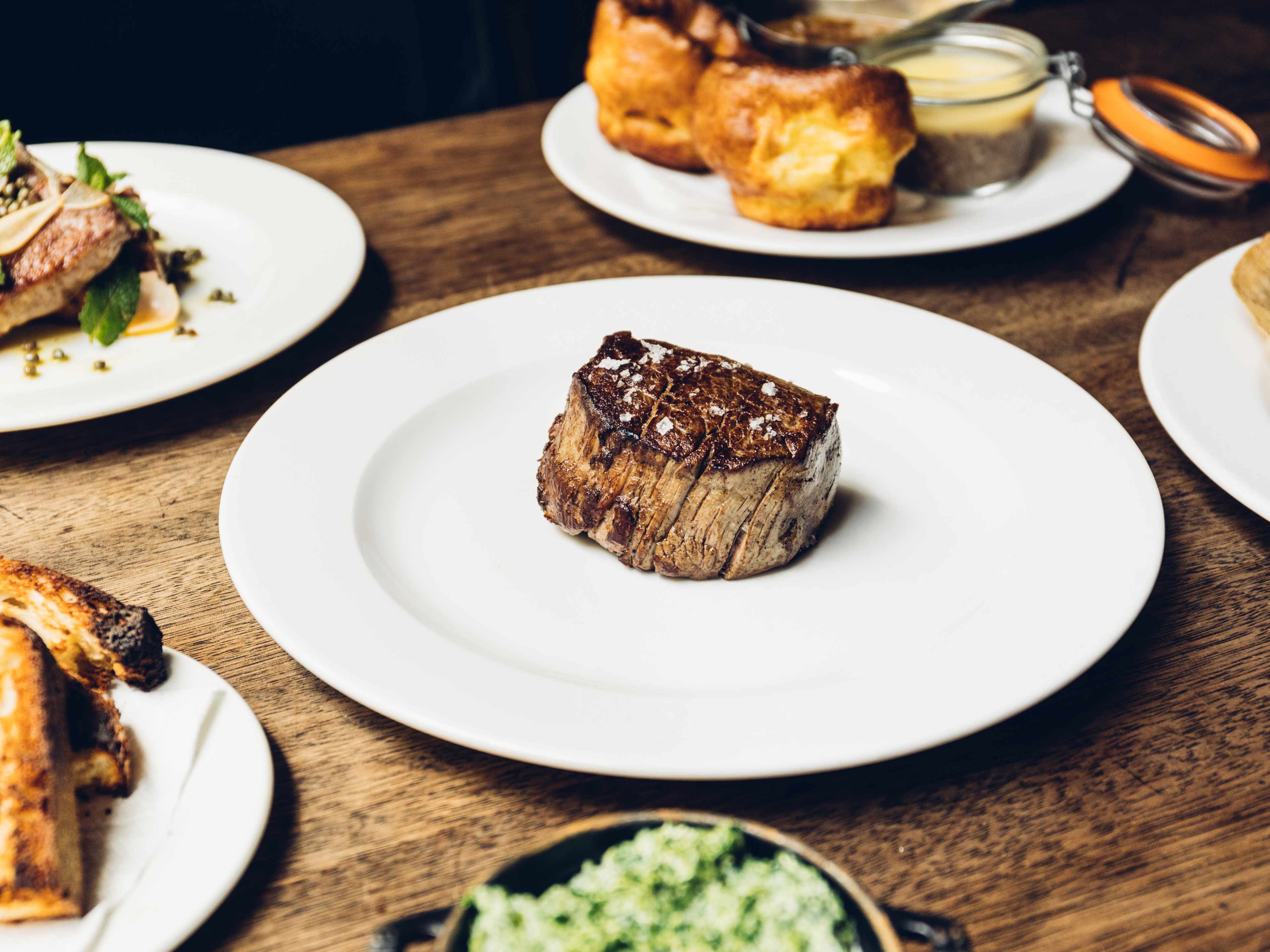 A filet mignon, with yorkshire puddings and lamb on the side.