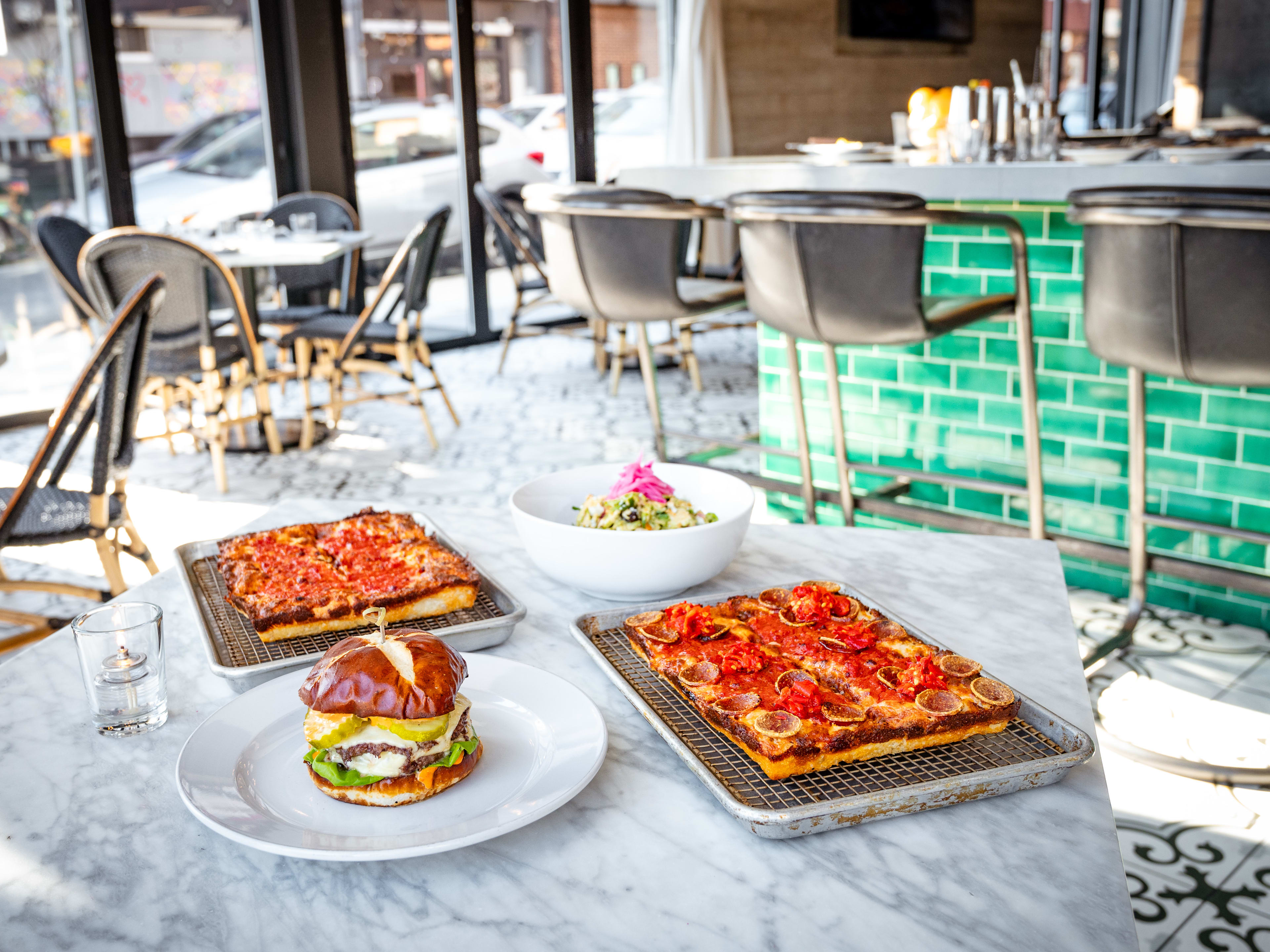 This is a pizza, burger, and salad spread from Emmy Squared.