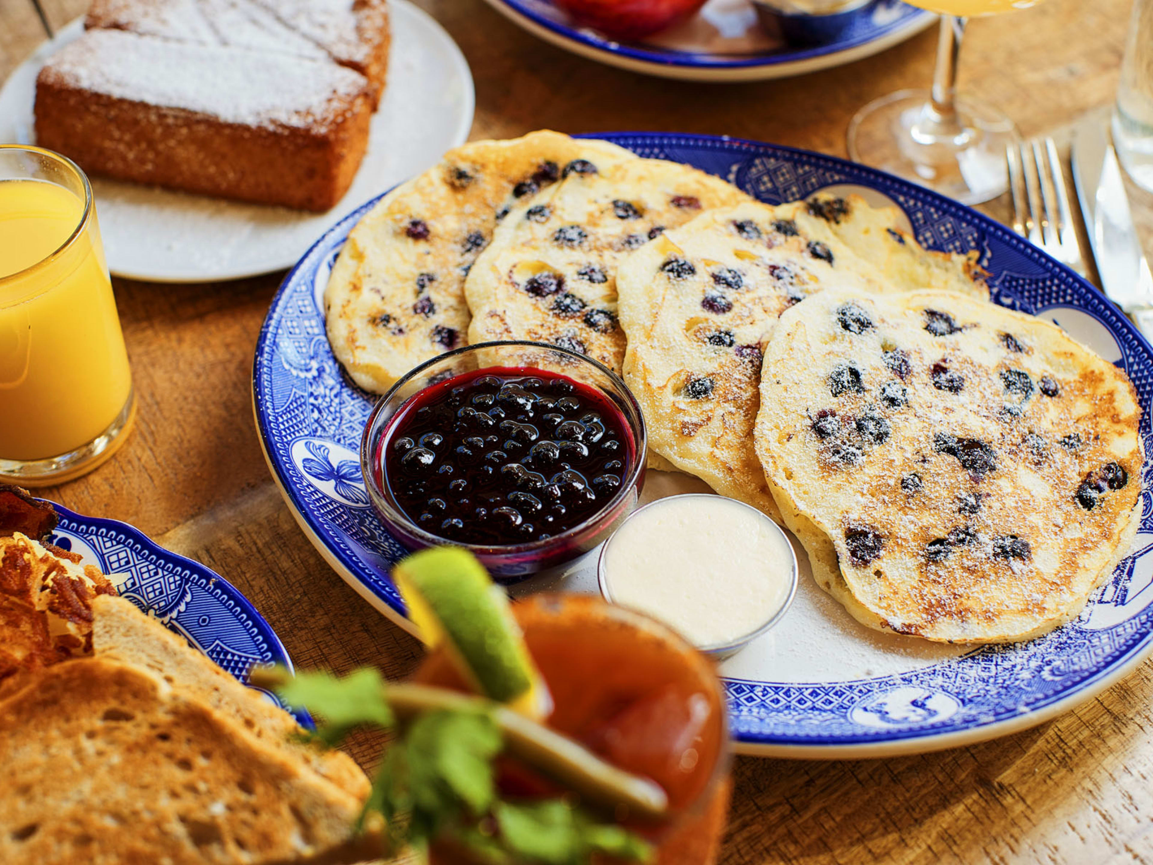 blueberry pancakes on a plate with butter and sauce