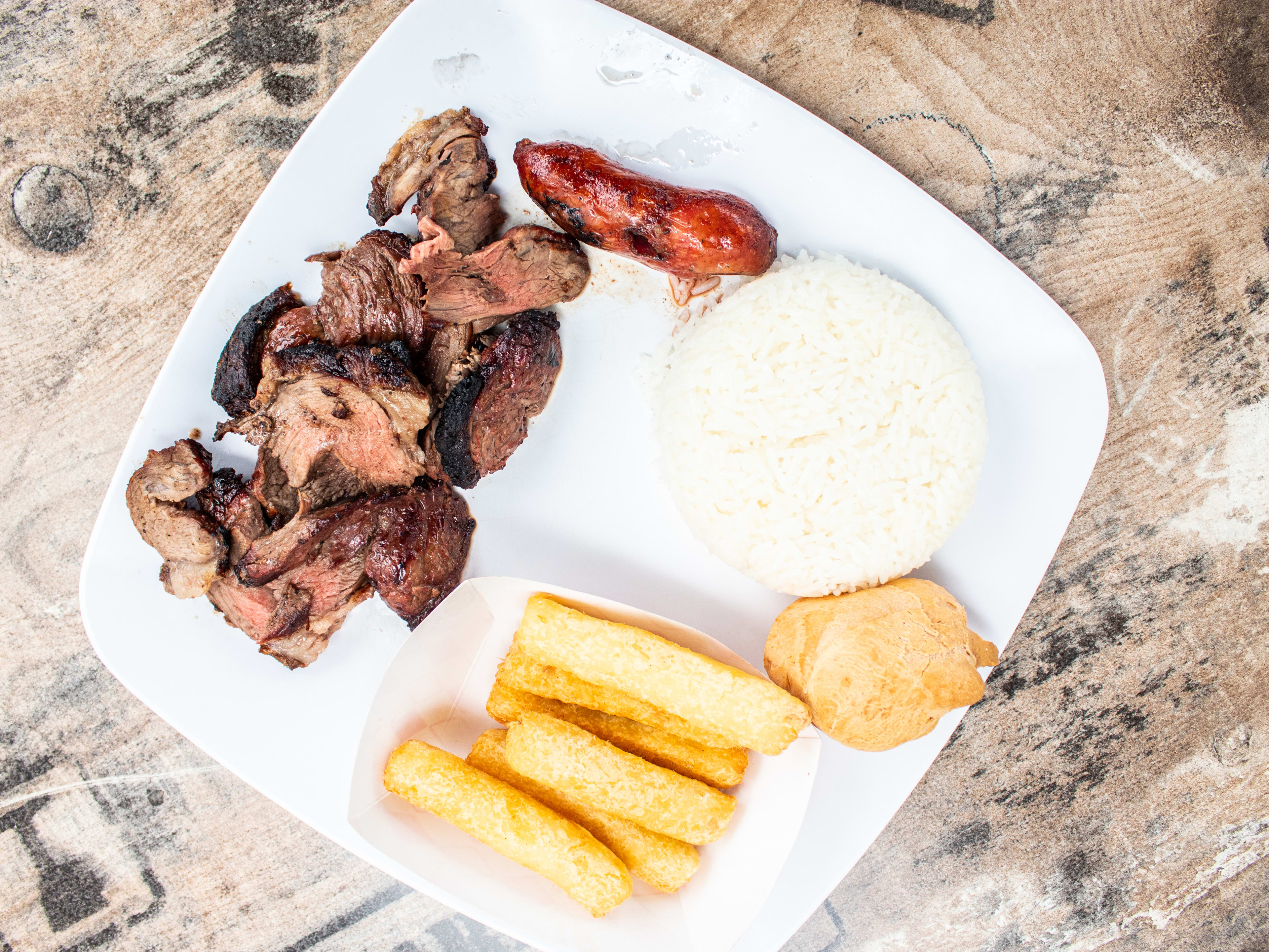 A plate of steak, rice, and yucca.