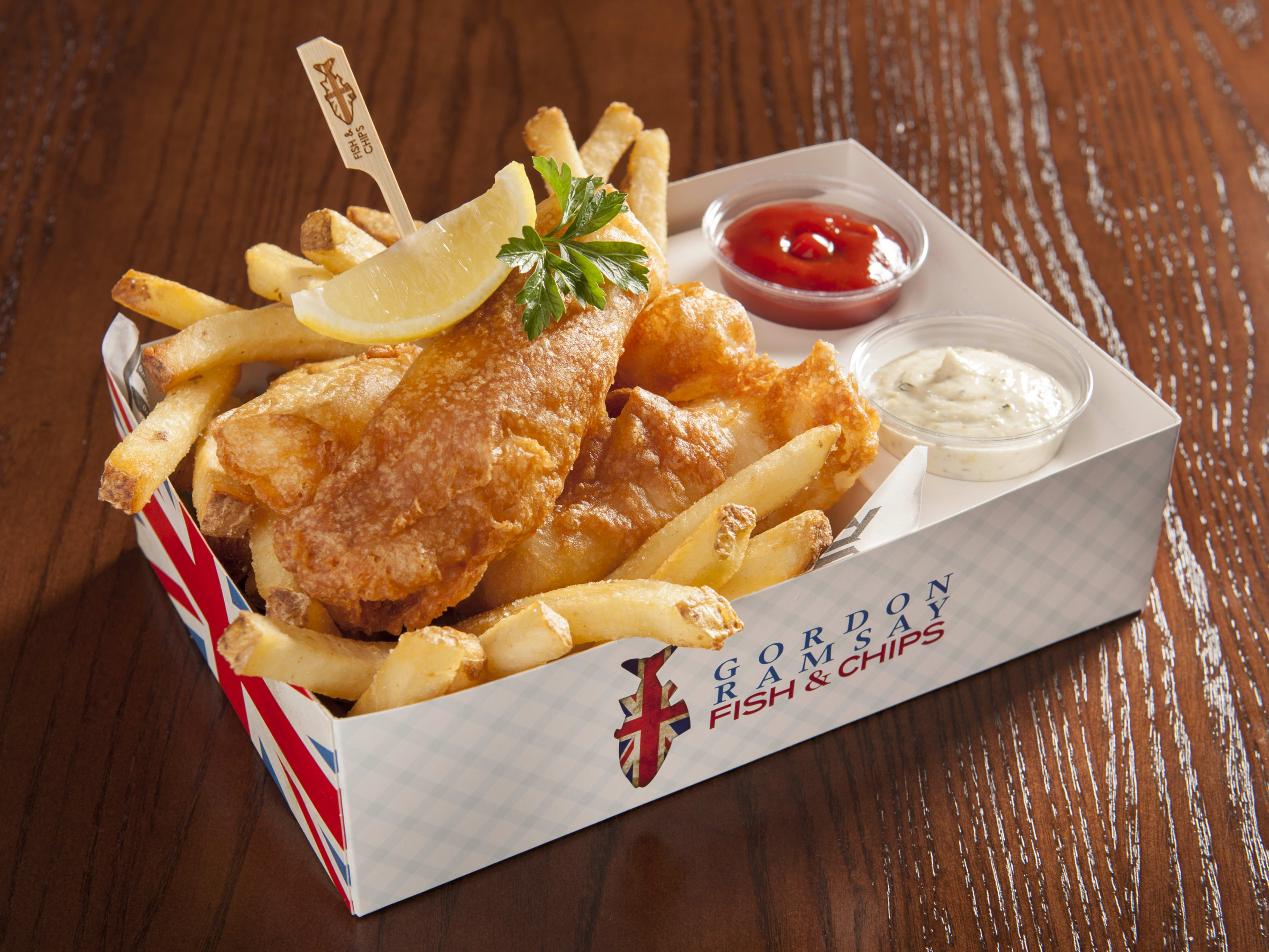 paper box with fish and chips and sauces inside it