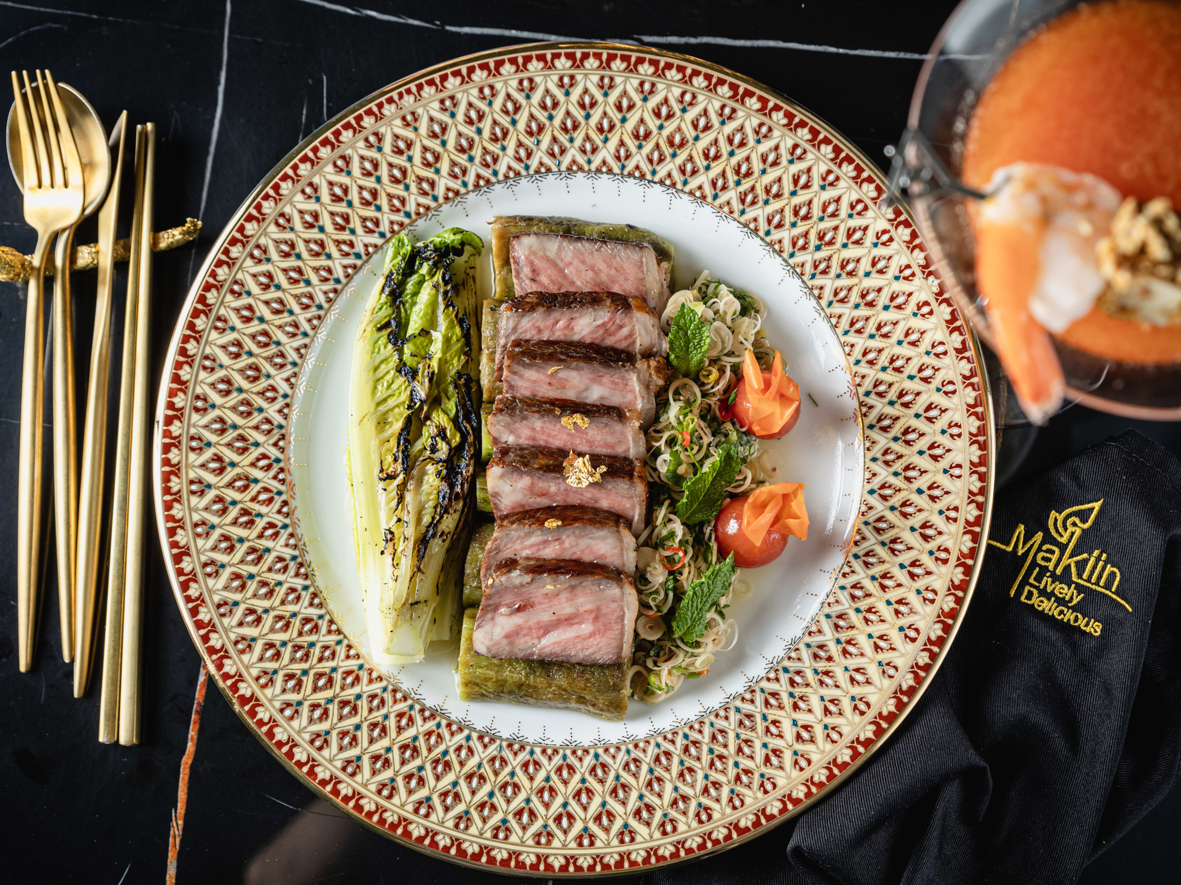 ornate plate of sliced meat with gold silverware