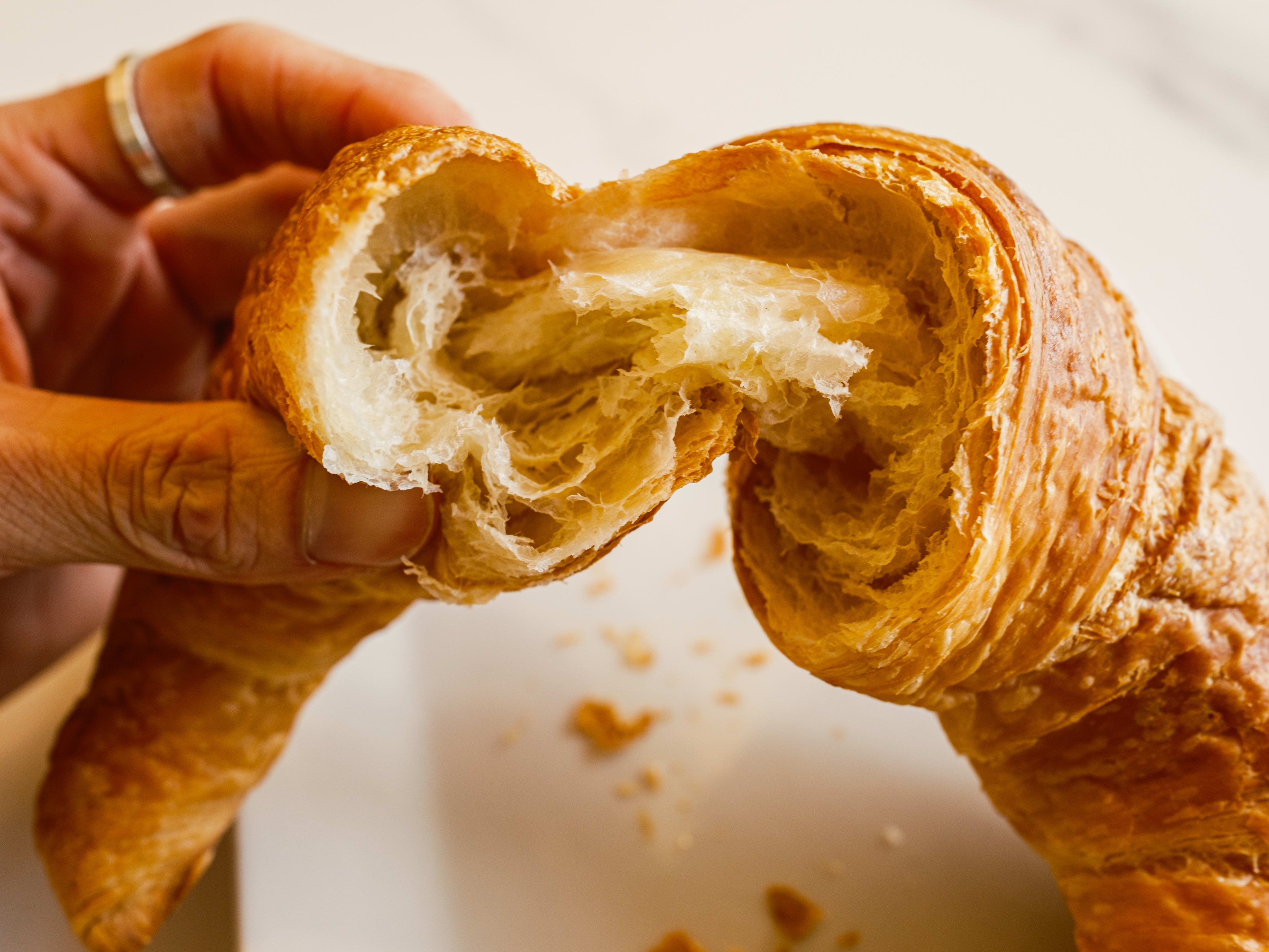 A croissant getting ripped in half.